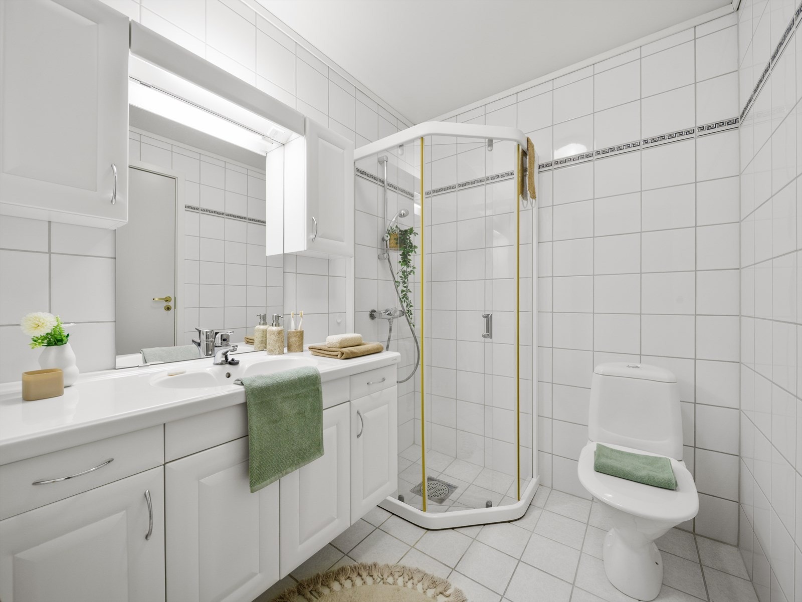 Baderomsinnredning med nedfelt servant, toalett og dusjvegger/hjørne. Det er skyvedør til vaskerom som har utslagskum og opplegg for vaskemaskin. Galleribilde
