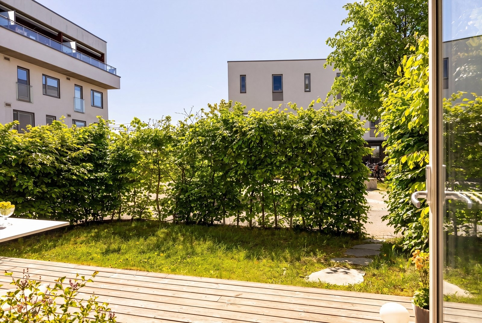 Fra stuen er det direkte utgang til terrasse med påkostet kebony terrassebord. Godt skjermet bak hekk, men likevel med nærhet til å følge med på lekeplassen. Galleribilde