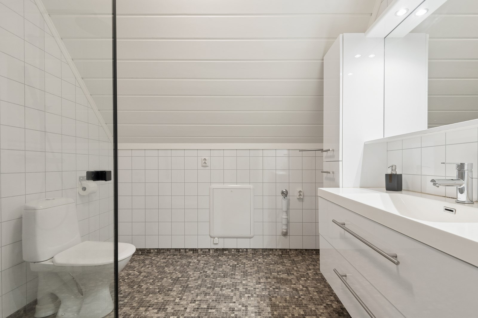 Badet i andre etasje har vinylbelegg på gulv med varmekabler og opplegg for vaskemaskin. Galleribilde