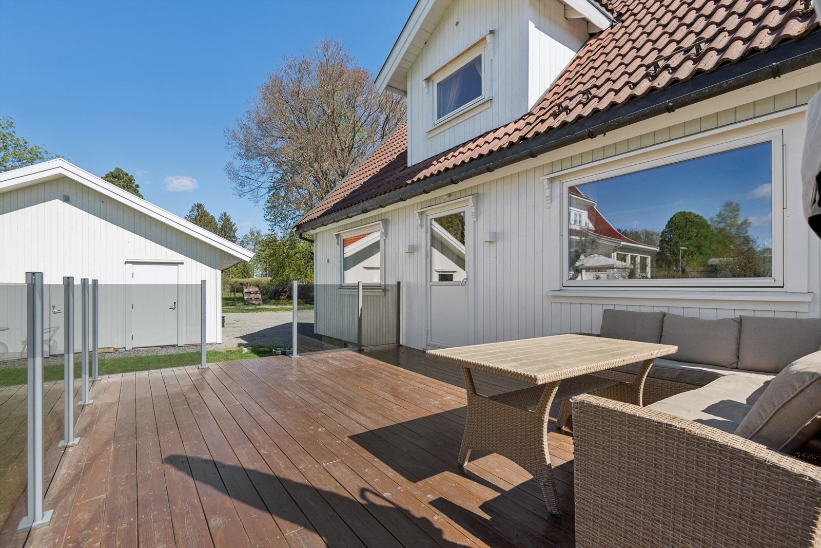 Uteplassen har impregnerte terrassebord og et stilrent glassrekkverk. Galleribilde