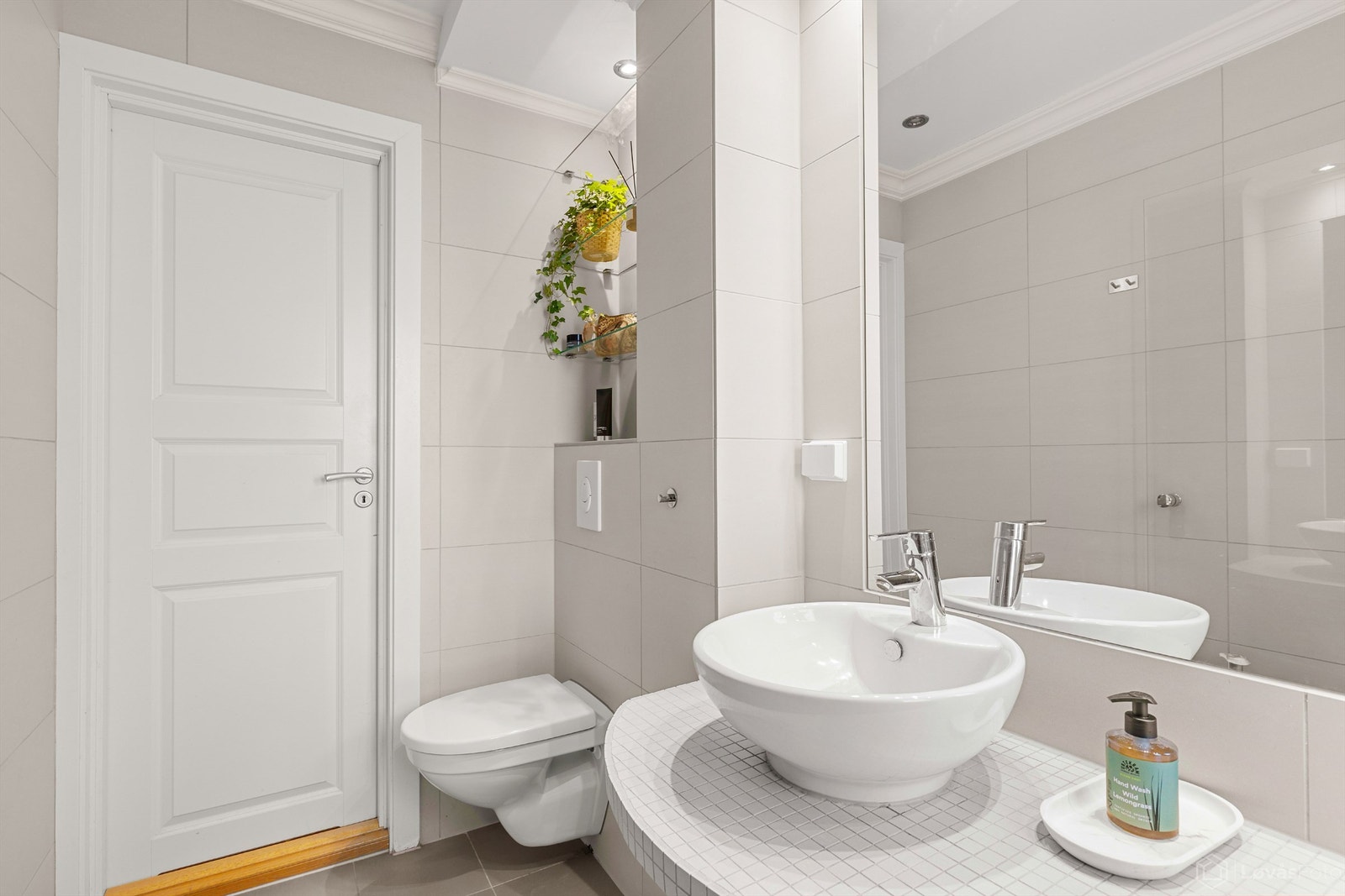 Badet er utstyrt med vegghengt toalett med innebygget sisterne. Galleribilde