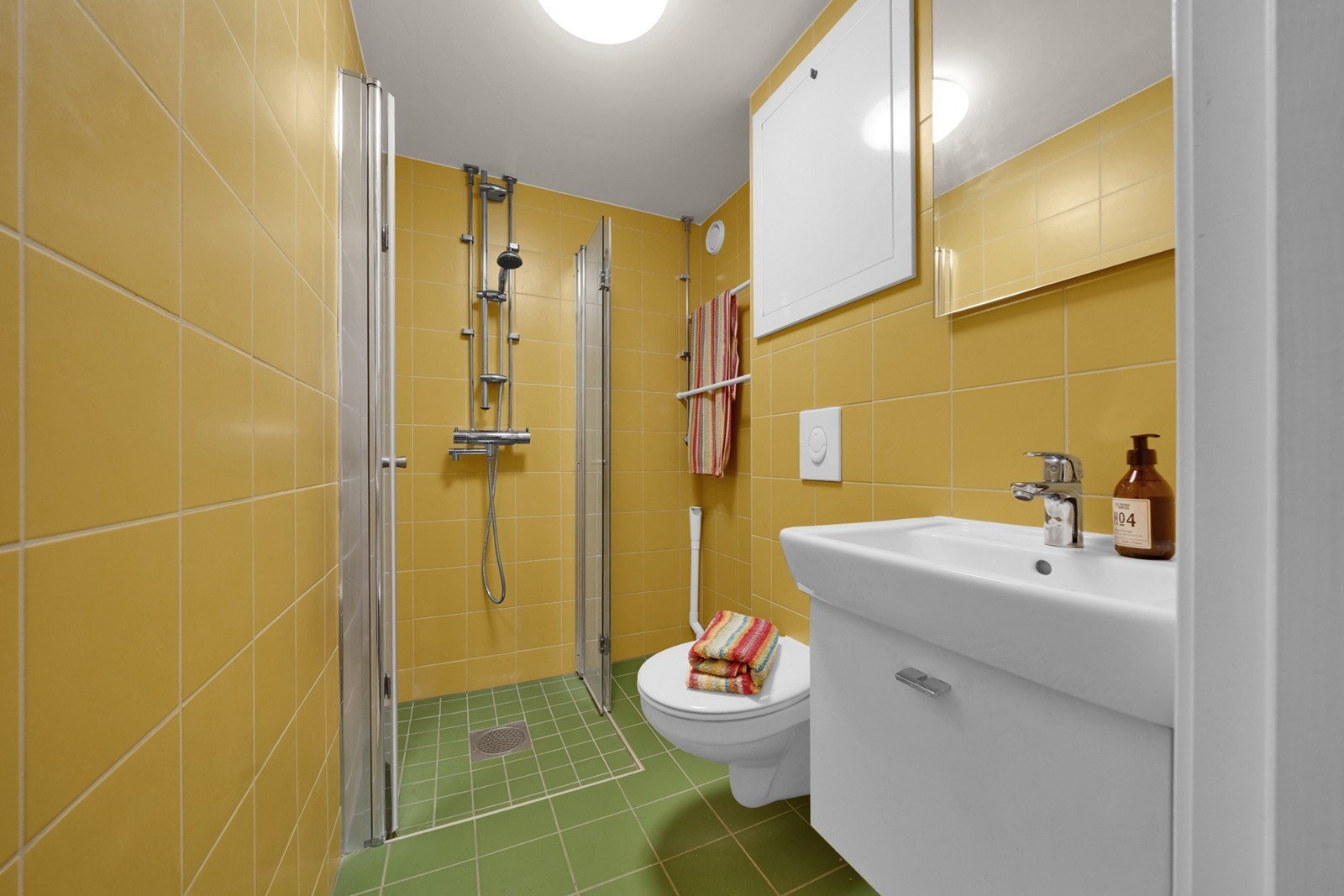 Badet har et unikt uttrykk i retrostil fra 2022 med elektriske varmekabler og opplegg for vaskemaskin. Badet ble pusset opp i regi av borettslaget. Galleribilde