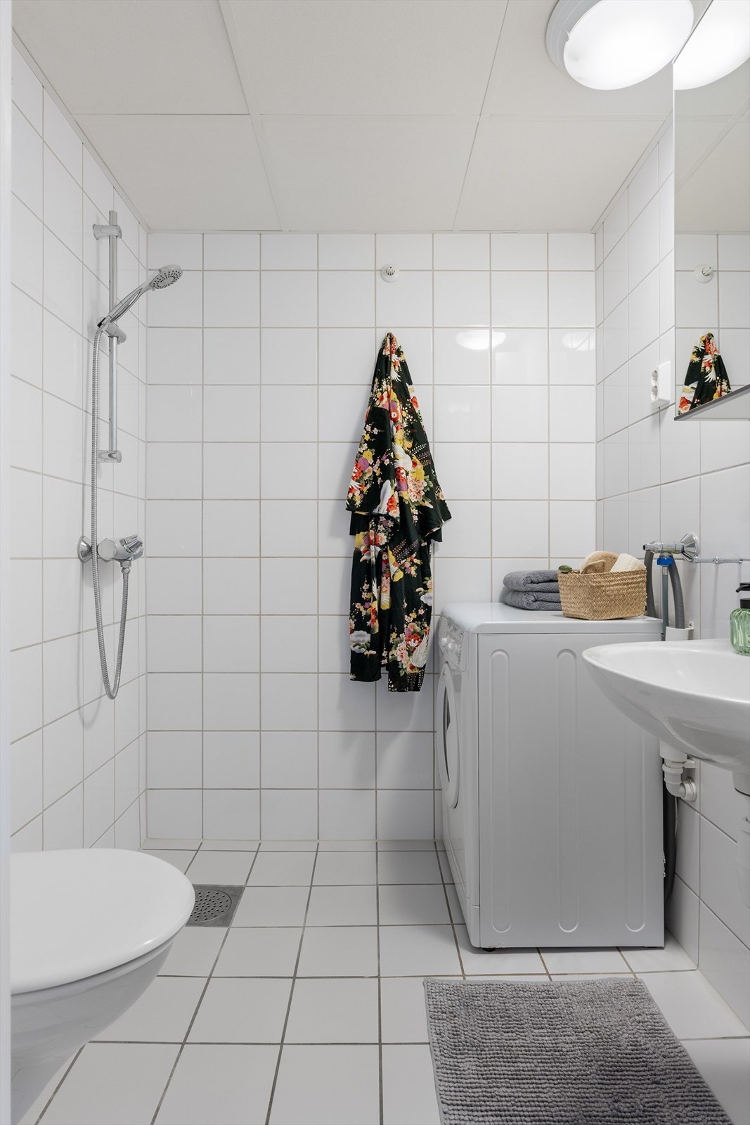 Baderommet er innredet med servant og speilskap, dusj, toalett og opplegg for vaskemaskin. Galleribilde