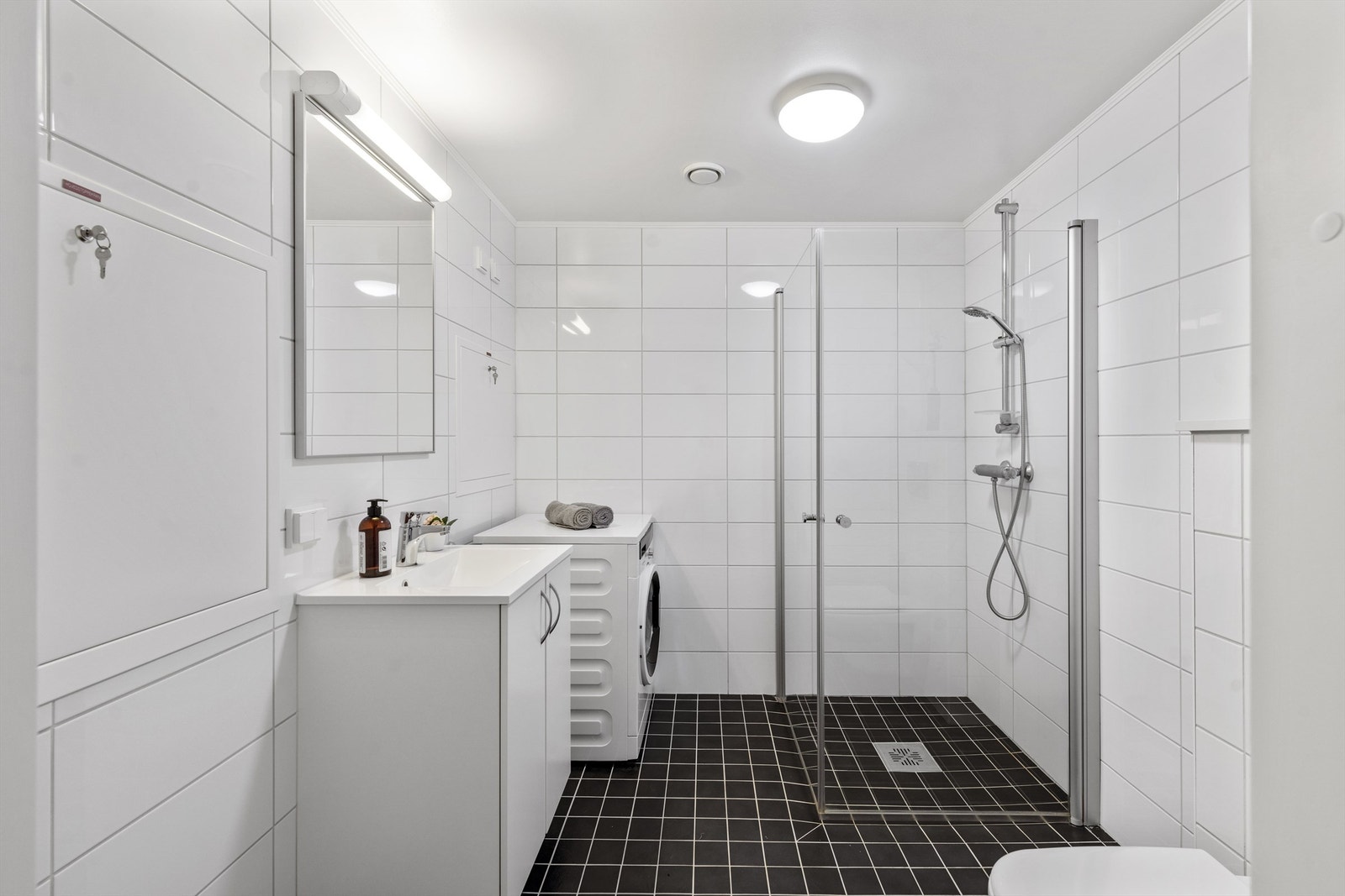 Pent flislagt bad med innfellbare dusjdører og vannbåren varme i gulv. Det er opplegg for vaskemaskin på badet. Galleribilde