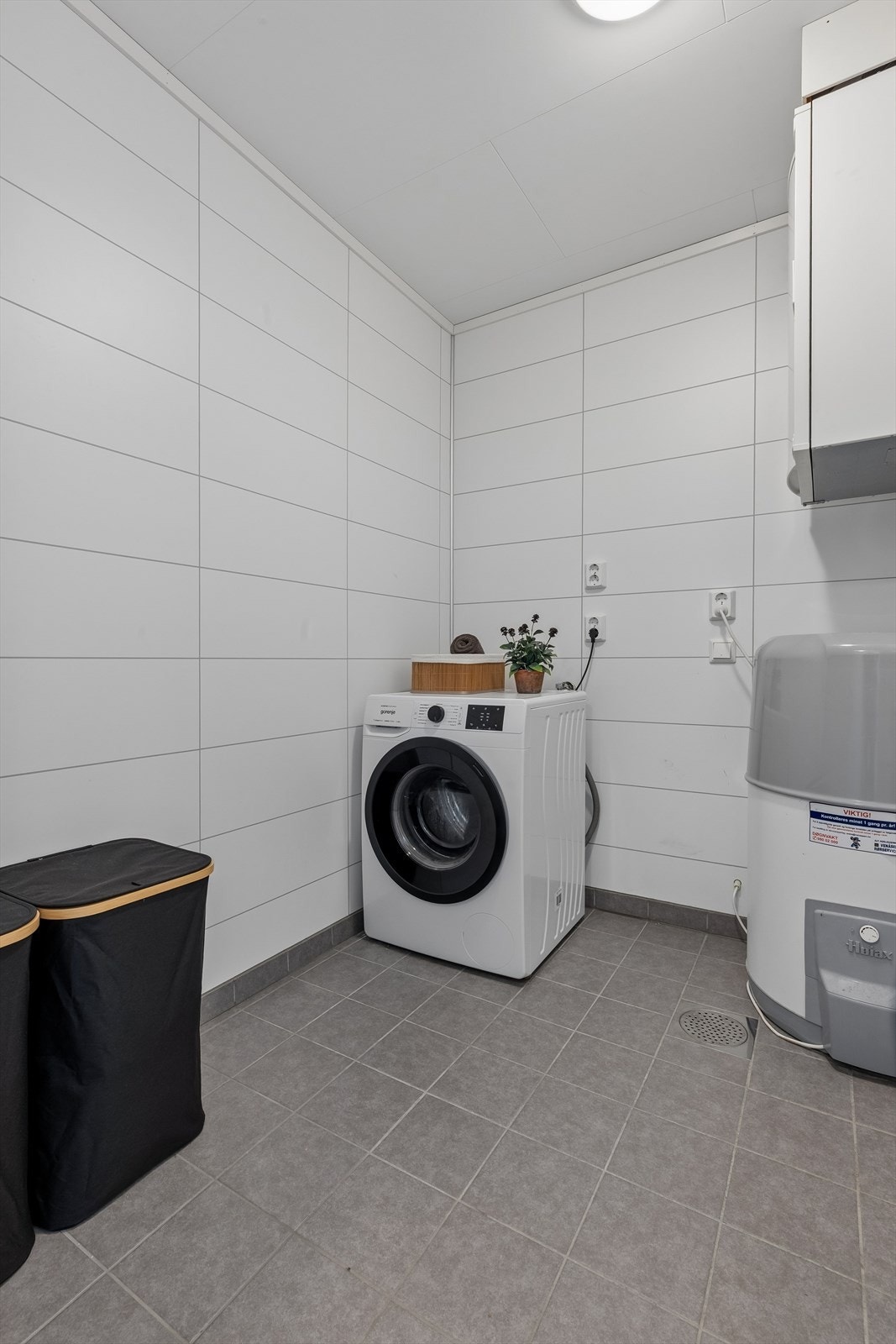 Separat vaskerom med flislagt gulv, gulvvarme og opplegg for vaskemaskin. Her er det god plass til å sette opp hylleløsning, som gir deg ekstra med lagringsplass. Galleribilde