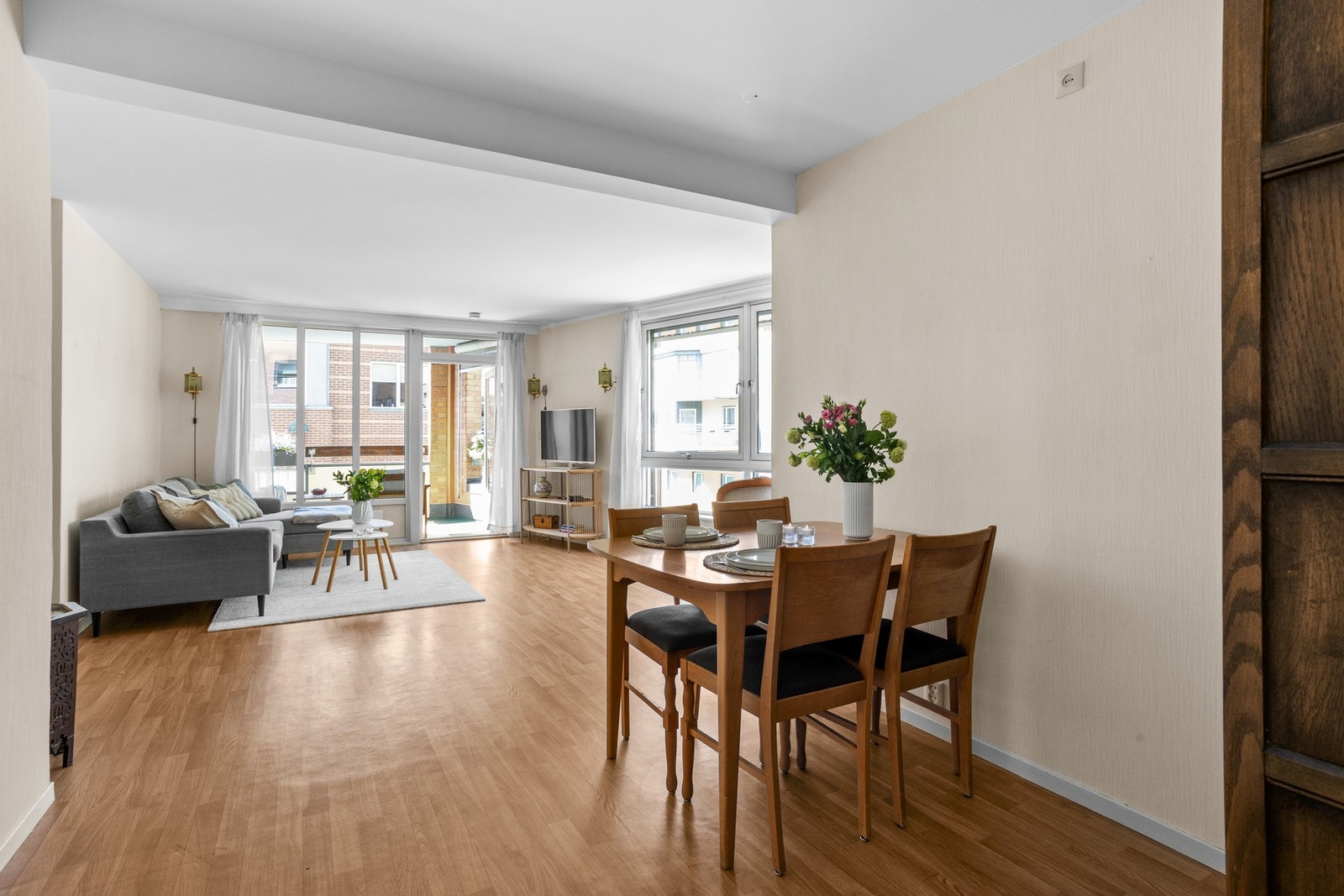 Lys stue med belegg på gulv, tapetserte vegger og malt himling Galleribilde