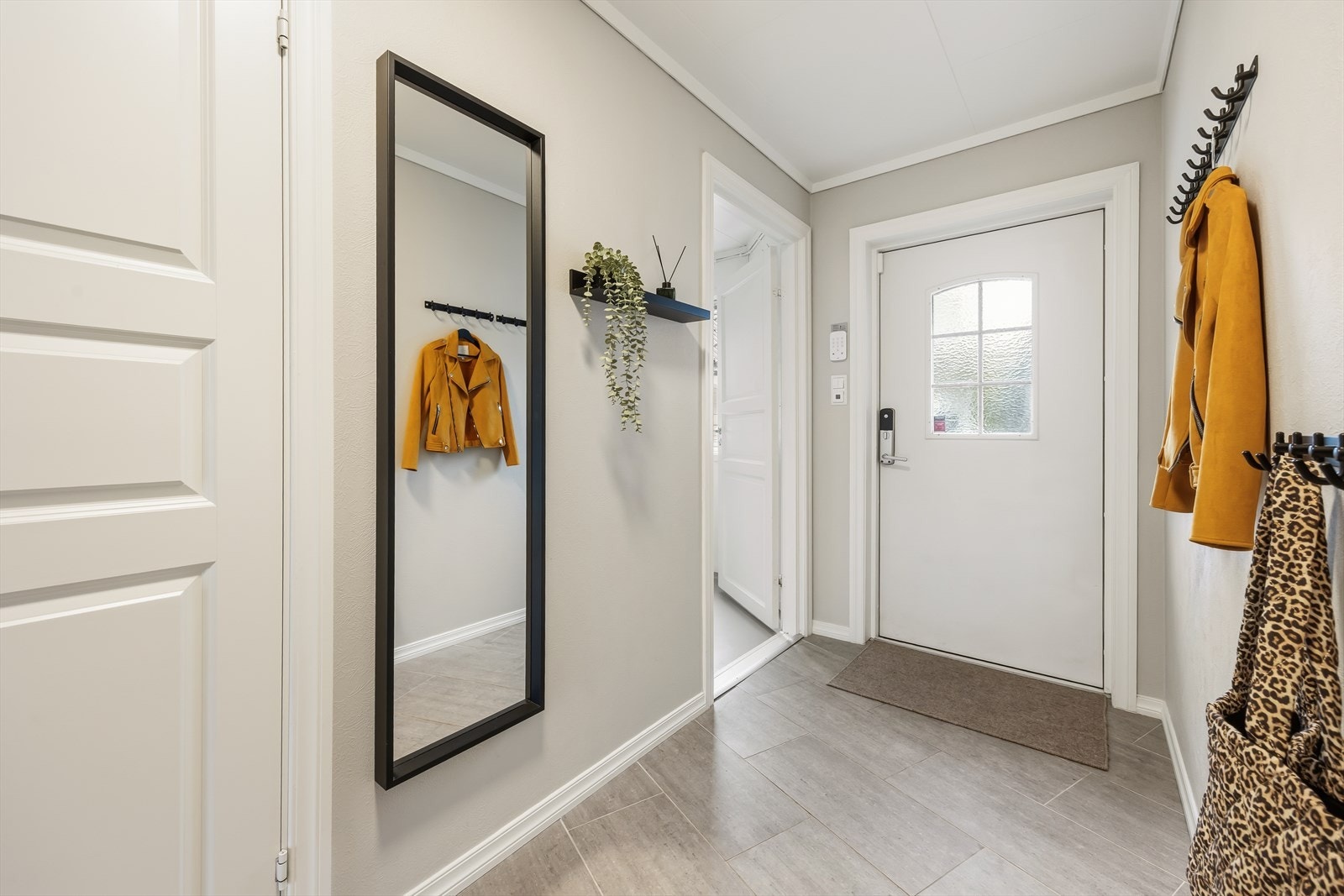 Innbydende entré med flislagt gulv og plass til å henge fra seg yttertøy. Galleribilde