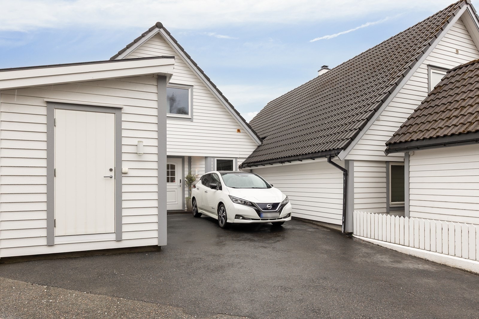 Ved inngangspartiet er det asfaltert parkeringsplass med elbillader og en praktisk, utvendig bod på 11 m² Galleribilde