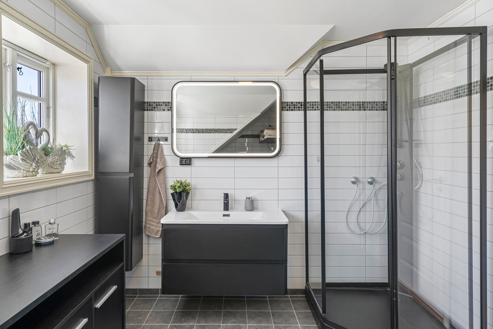 Badet i 2. etasje er utstyrt med servantinnredning, dusjkabinett, opplefgg for vaskemaskin og toalett. Galleribilde