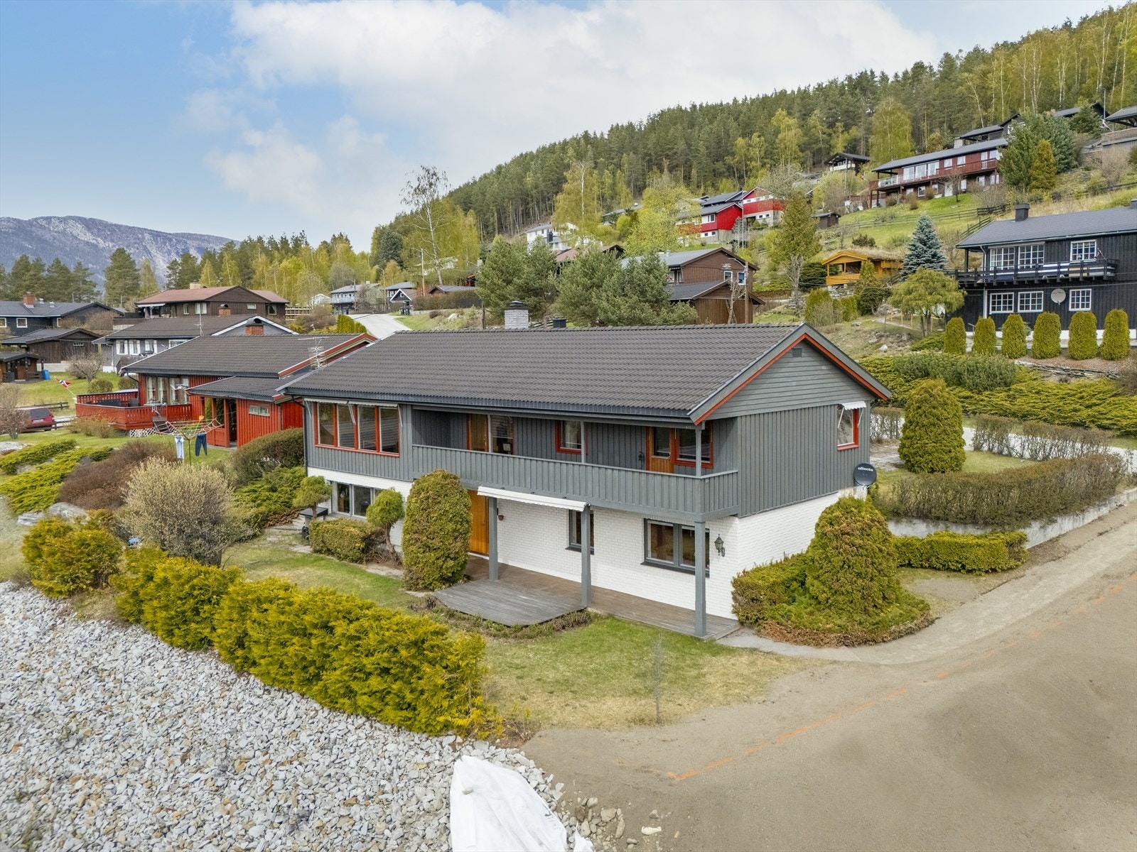 Fasaden er kledd med en kombinasjon av liggende trepanel og teglstein. Galleribilde