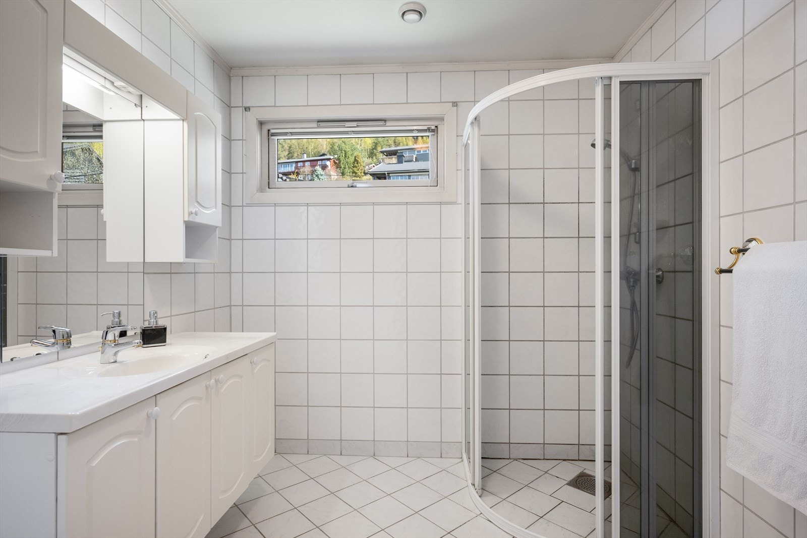 Badet i hovedetasjen har fliser på gulv og vegger, og er utstyrt med en lys innredning og dusjhjørne. Oppgradering må påregnes. Galleribilde