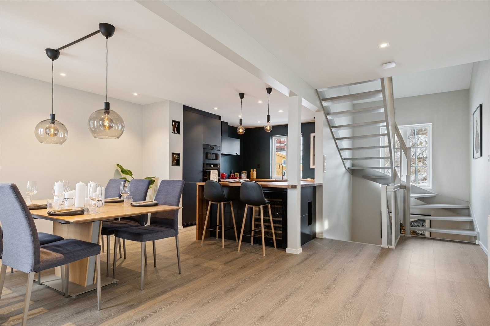 Stilrent og moderne kjøkkenområde med tilhørende spisestue og praktisk barløsning for både matlaging og sosialt samvær. Galleribilde