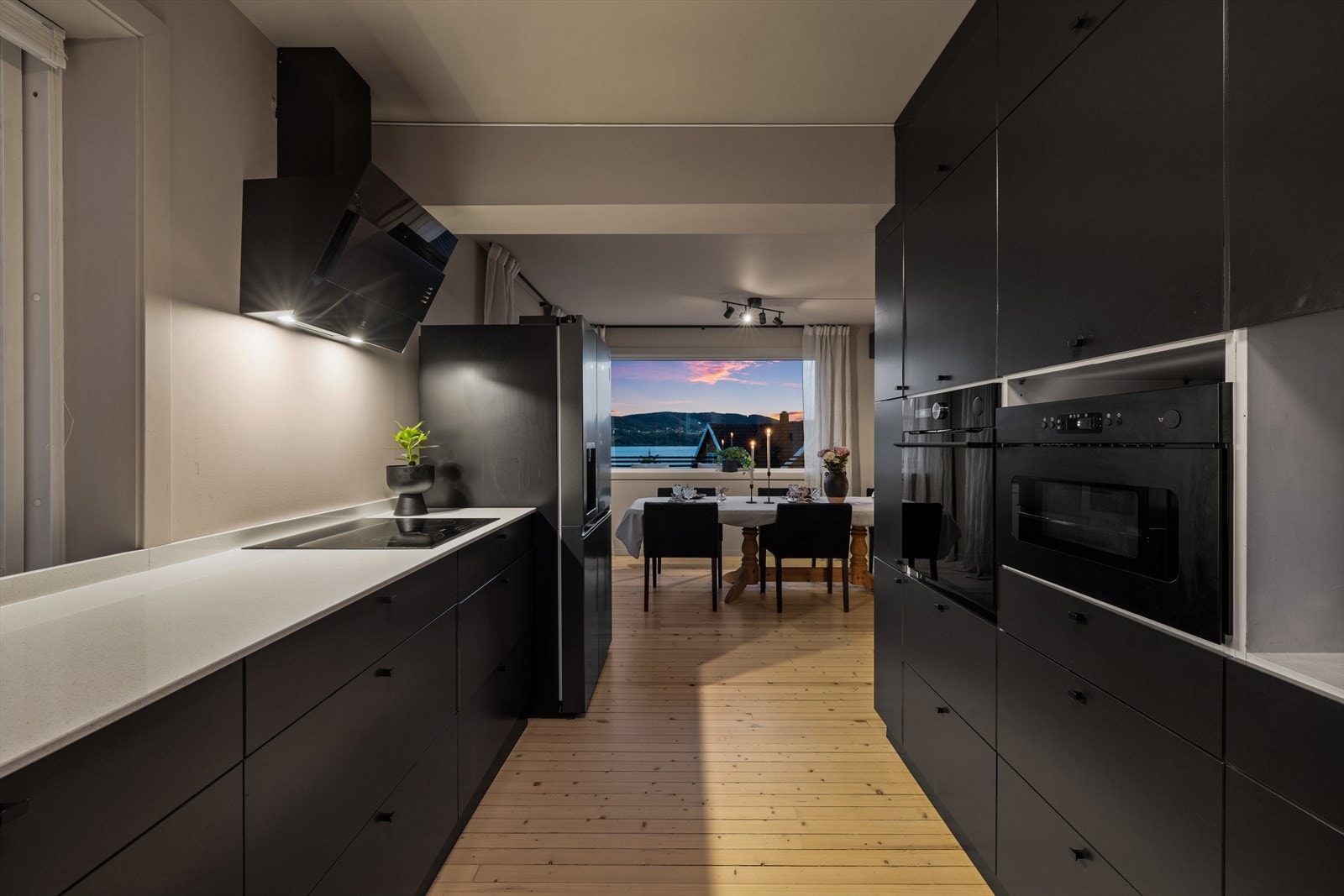 Takhøy innredning med glatte fronter og solid benkeplate i stein kompositt. Galleribilde