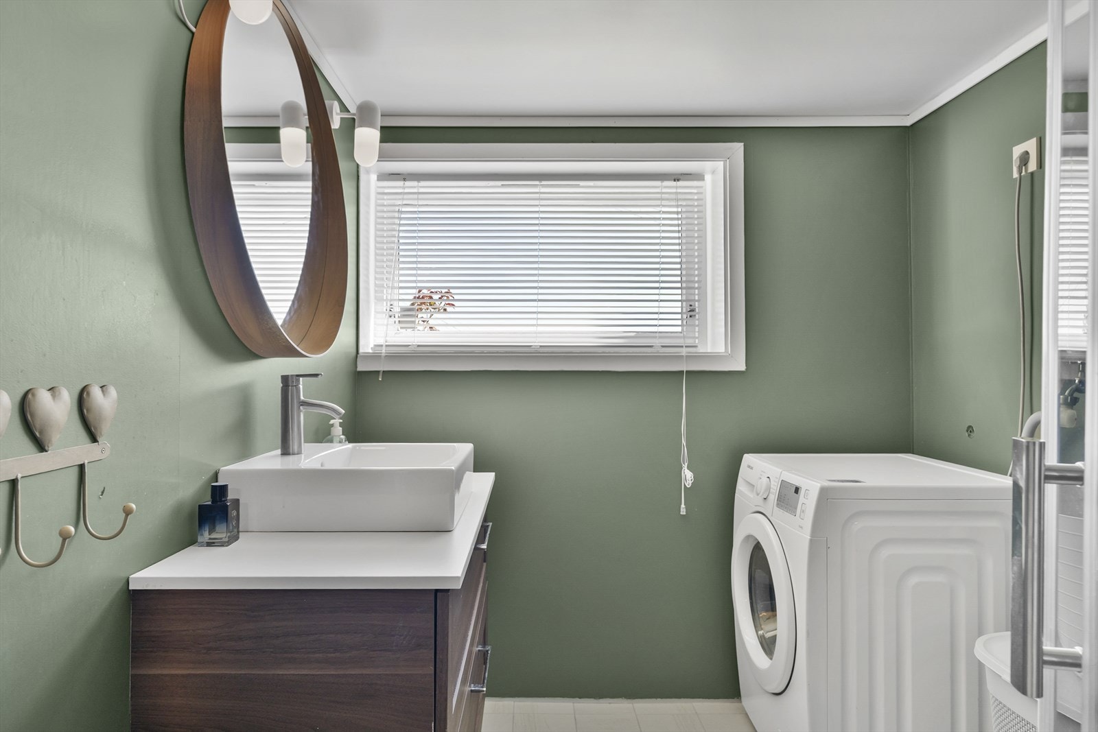 Badet har flislagt gulv med elektriske varmekabler og en fuktstyrt elektrisk vifte montert i 2023. Galleribilde