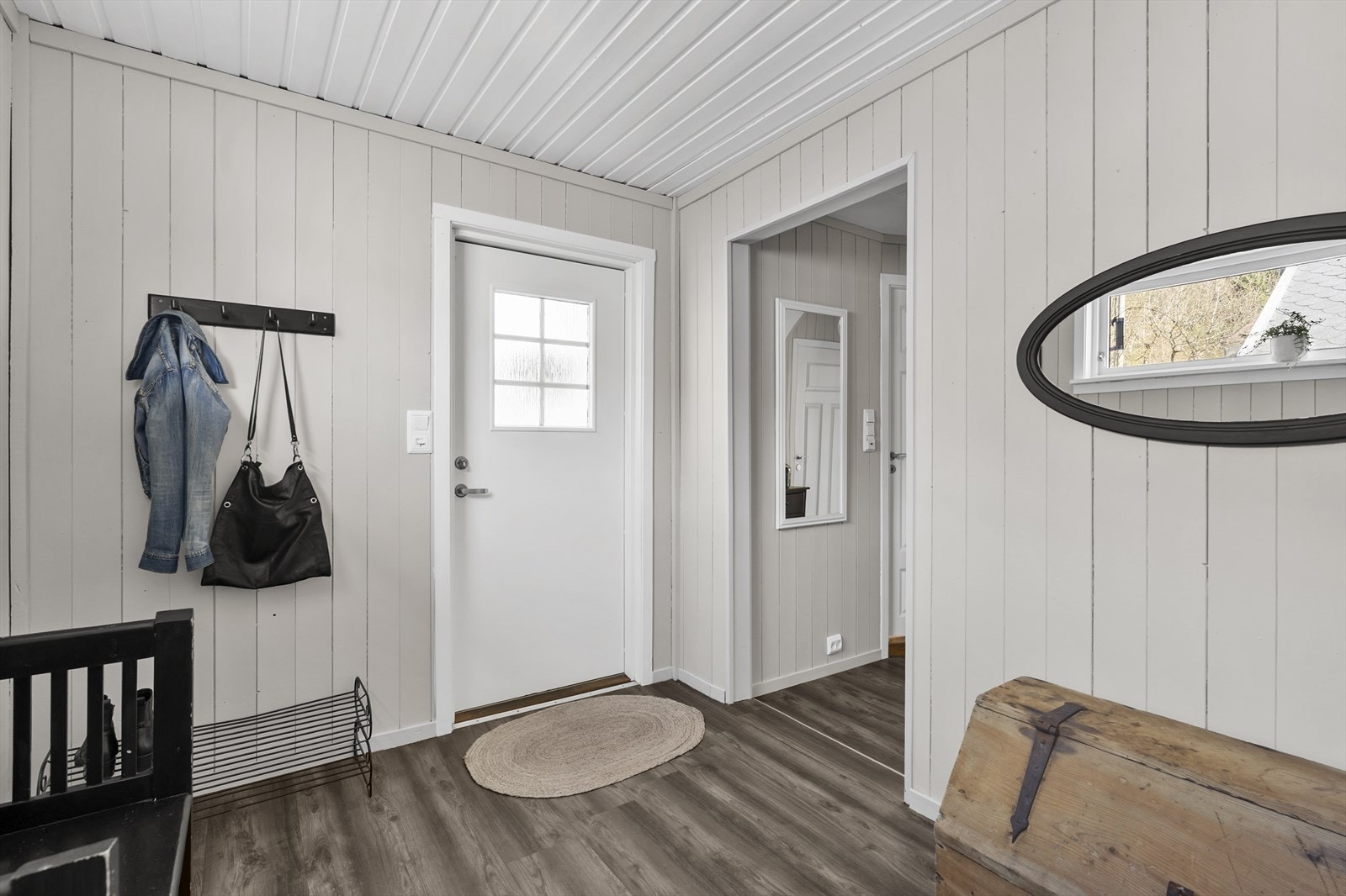 Velkommen inn i hovedetasjen. Entréen har laminat på gulvet og malte fyllingsdører inn til de andre rommene. Galleribilde