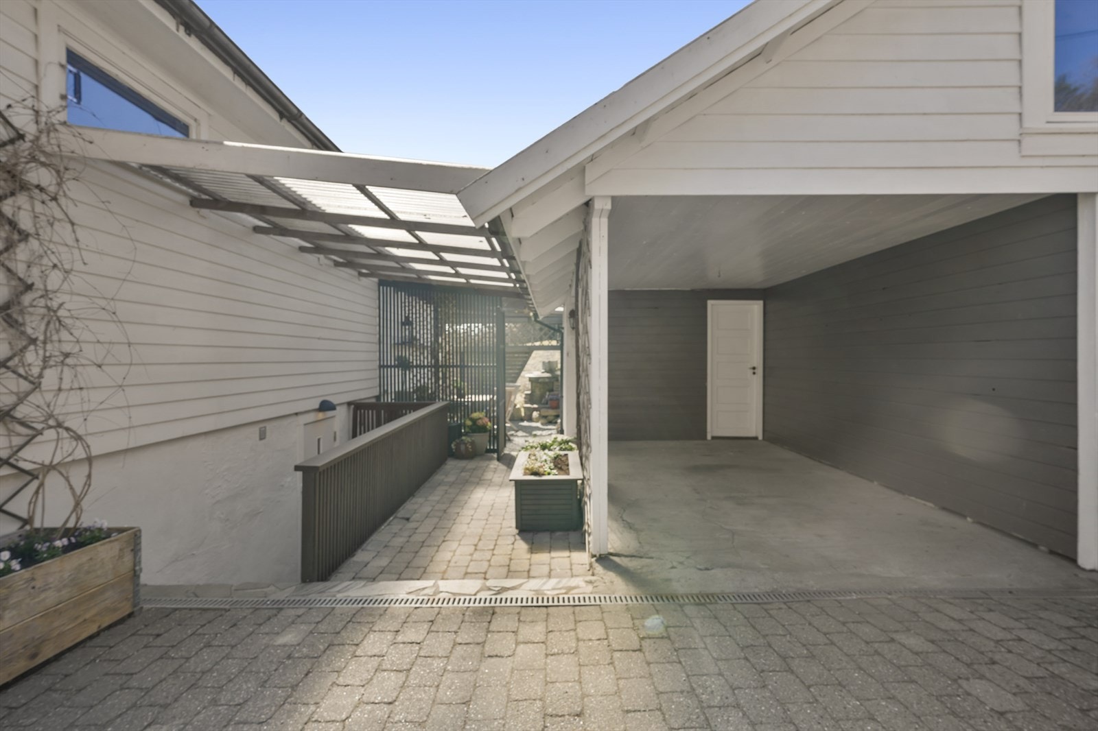 Carporten er praktisk plassert med et takoverbygg med nedgang til kjellerleiligheten Galleribilde