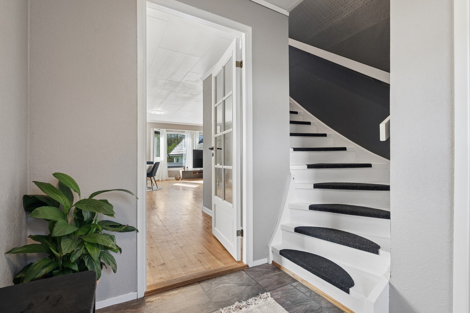 Fra entreen leder en glassdør inn til stuen, noe som skaper en åpen og luftig følelse. Galleribilde