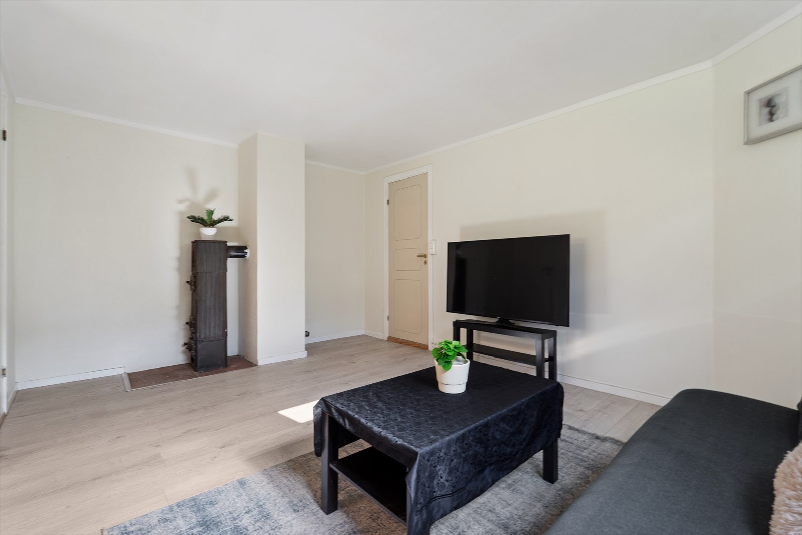 Stuedelen har plass til en sofagruppe og TV-løsning. Vedovnen varmer godt på kalde dager. Galleribilde