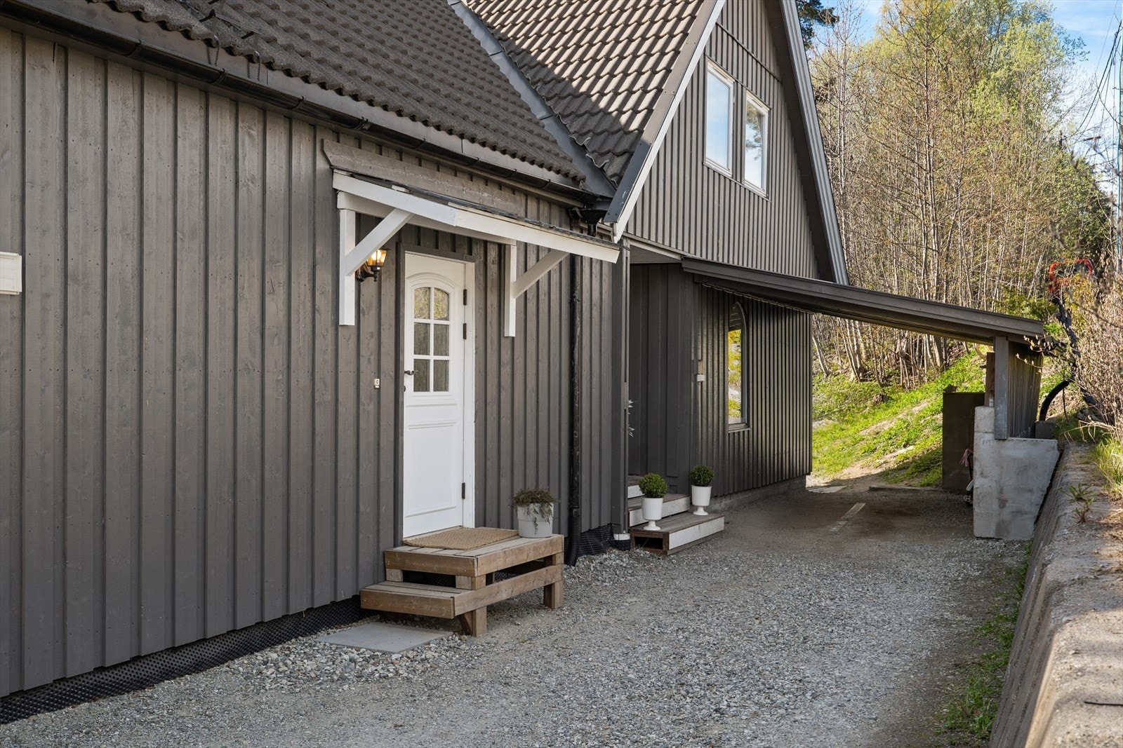 Eiendommen har parkering i carport og separate innganger til boligens ulike deler. Galleribilde