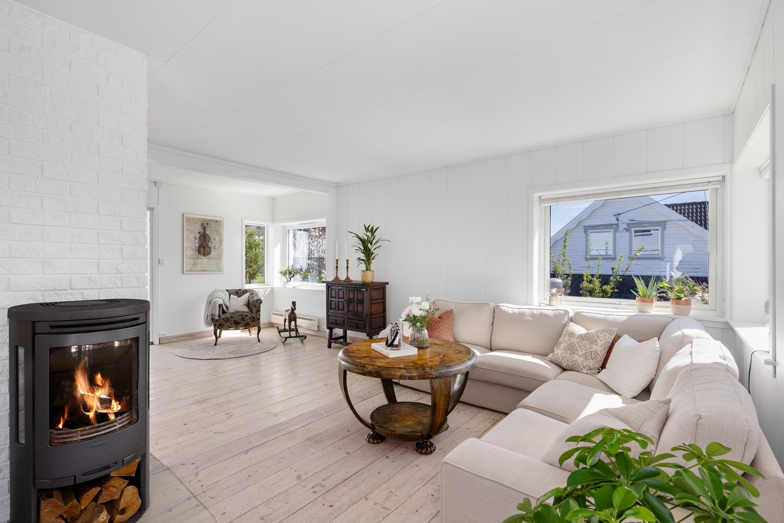 Hyggelig vinklestue med naturlig plassering av sofa og spisebord Galleribilde