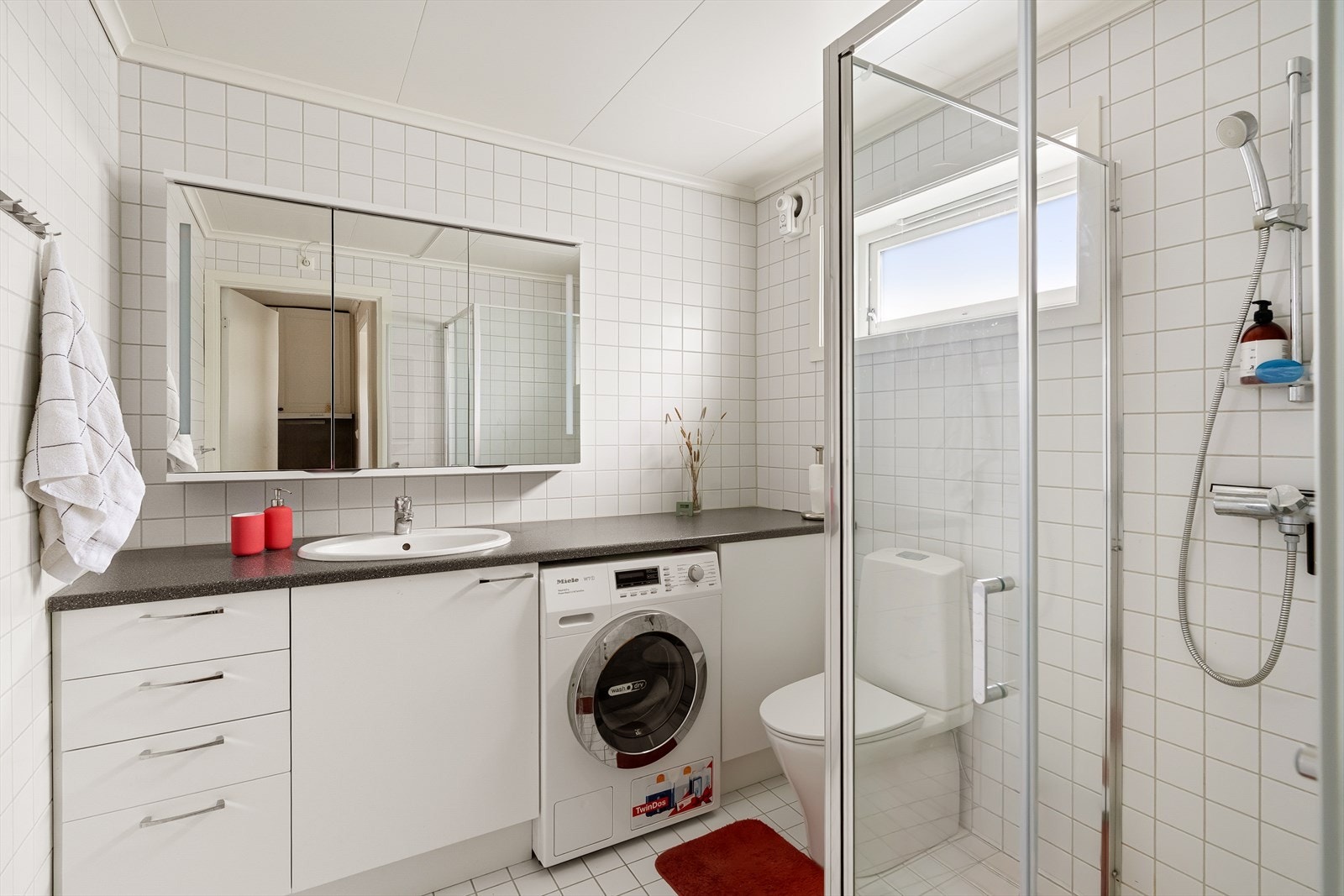 Helfliset bad som ble modernisert i 2020. Badet inneholder servant, toalett og dusjhjørne samt Miele kombinert vaskemaskin og tørketrommel som medfølger i handelen. Galleribilde