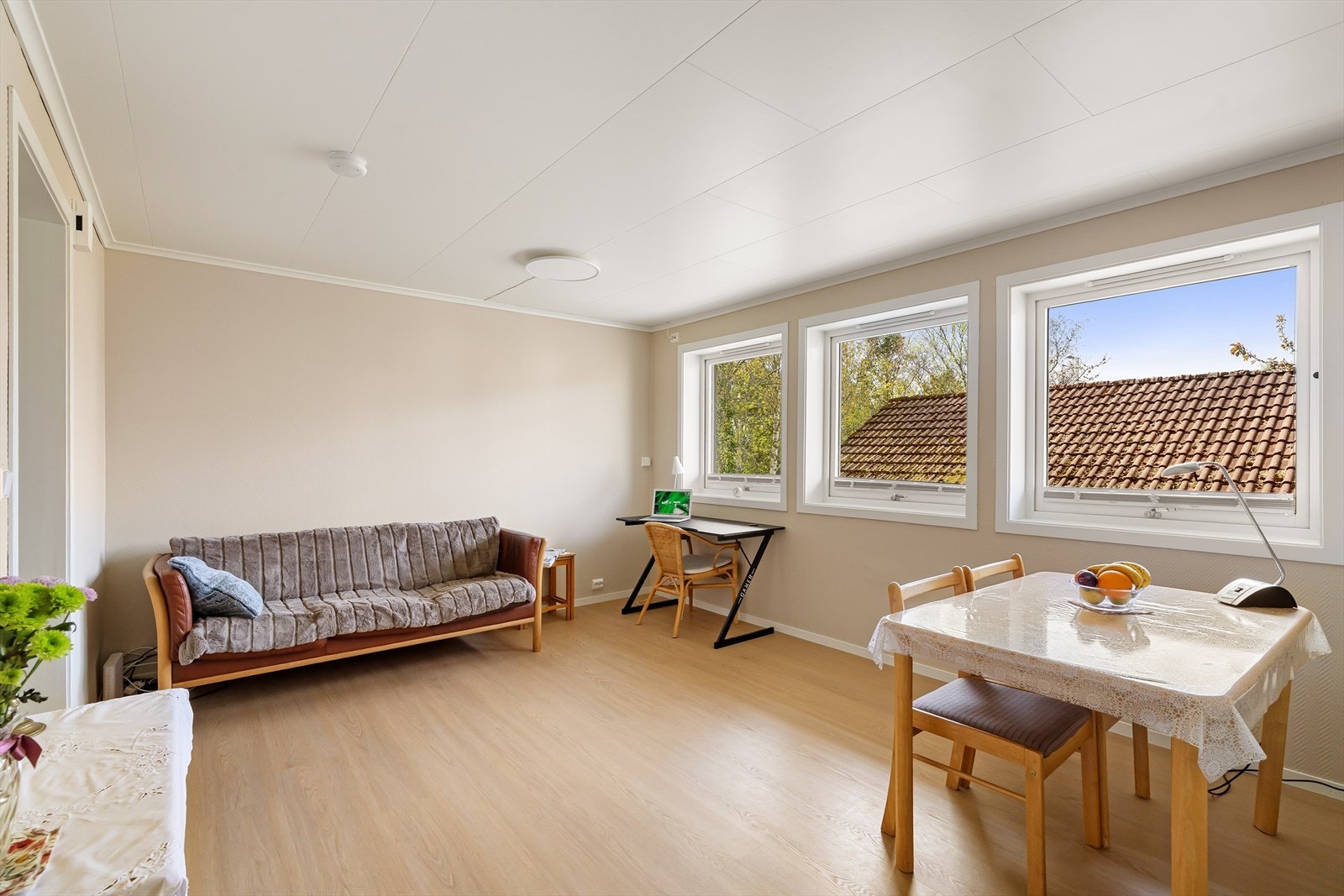 Stuen i utleiedelen har laminatgulv og plass til både sofagruppe og spisebord. (Sofa medfølger ikke i handelen) Galleribilde