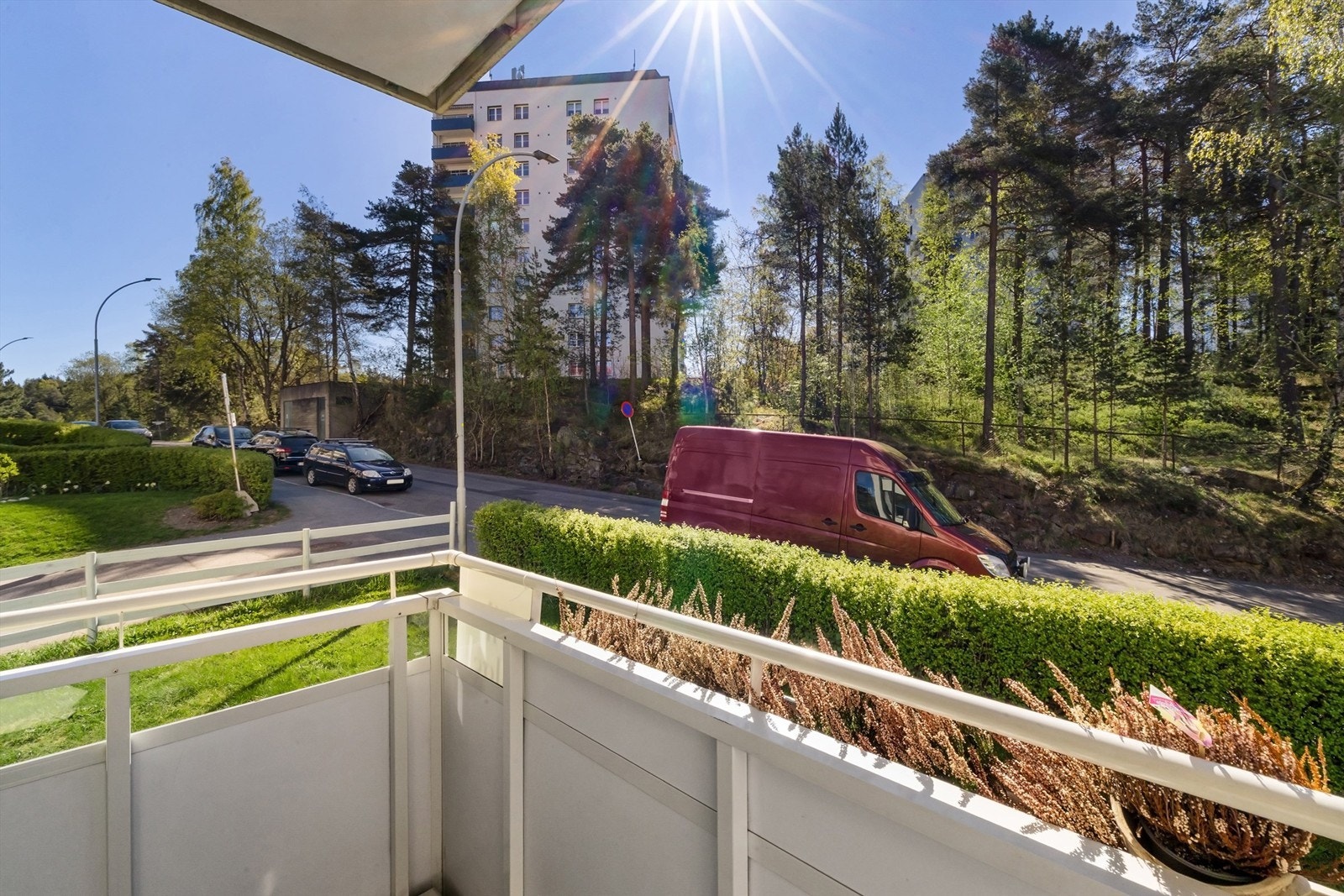 Balkongen vender ut mot felles gressplen og skogsholt på andre siden av gaten Galleribilde