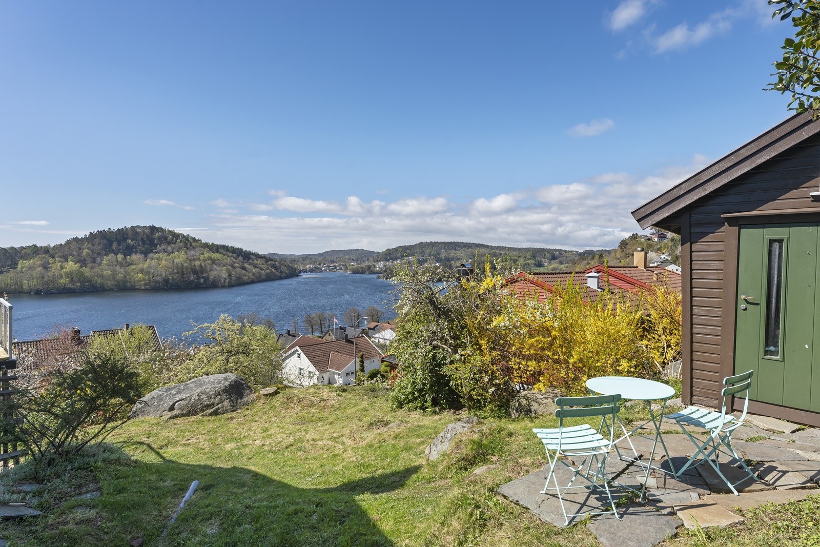 Praktisk utebod med lagringsplass. Her er etablert en liten uteplass med steinheller. Galleribilde