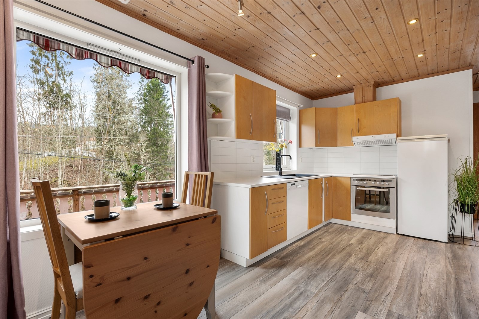 Innredningen har slette fronter og laminerte benkeplater med nedfelt oppvaskkum i svart kompositt, ett-greps vannkran. Videre er det integrerte hvitevarer som stekeovn, koketopp, oppvaskmaskin (uten dekkplate). Galleribilde