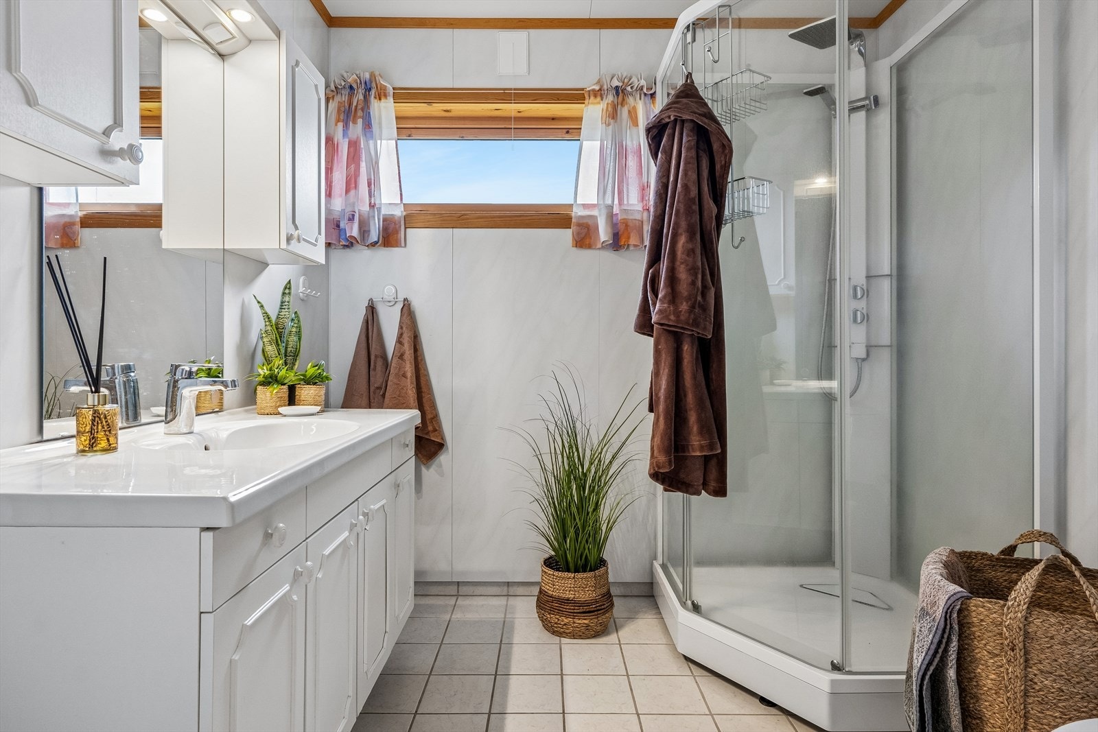 Badet er innredet med baderomsinnredning med heldekkende servant, dusjkabinett og gulvmontert toalett. Galleribilde