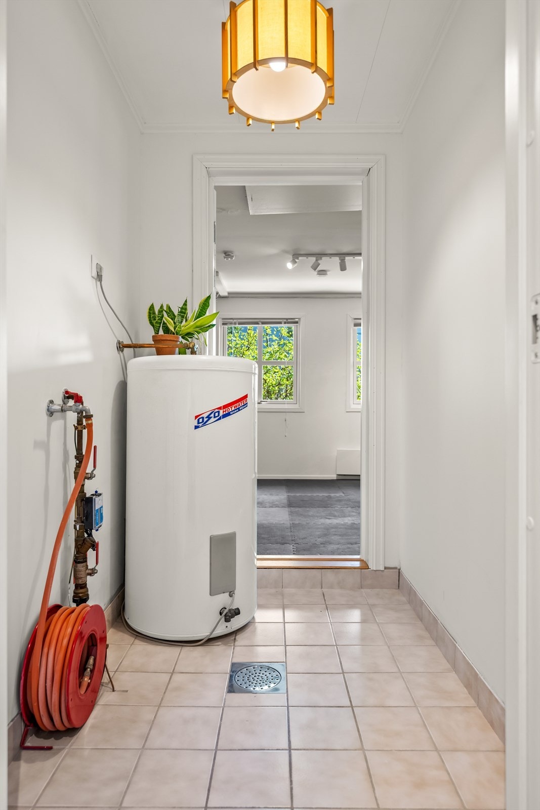 Fra en bod er det direkte adkomst til et innredet rom i den tidligere garasjen. Varmtvannsberederen på ca. 200 liter er plassert her. Galleribilde