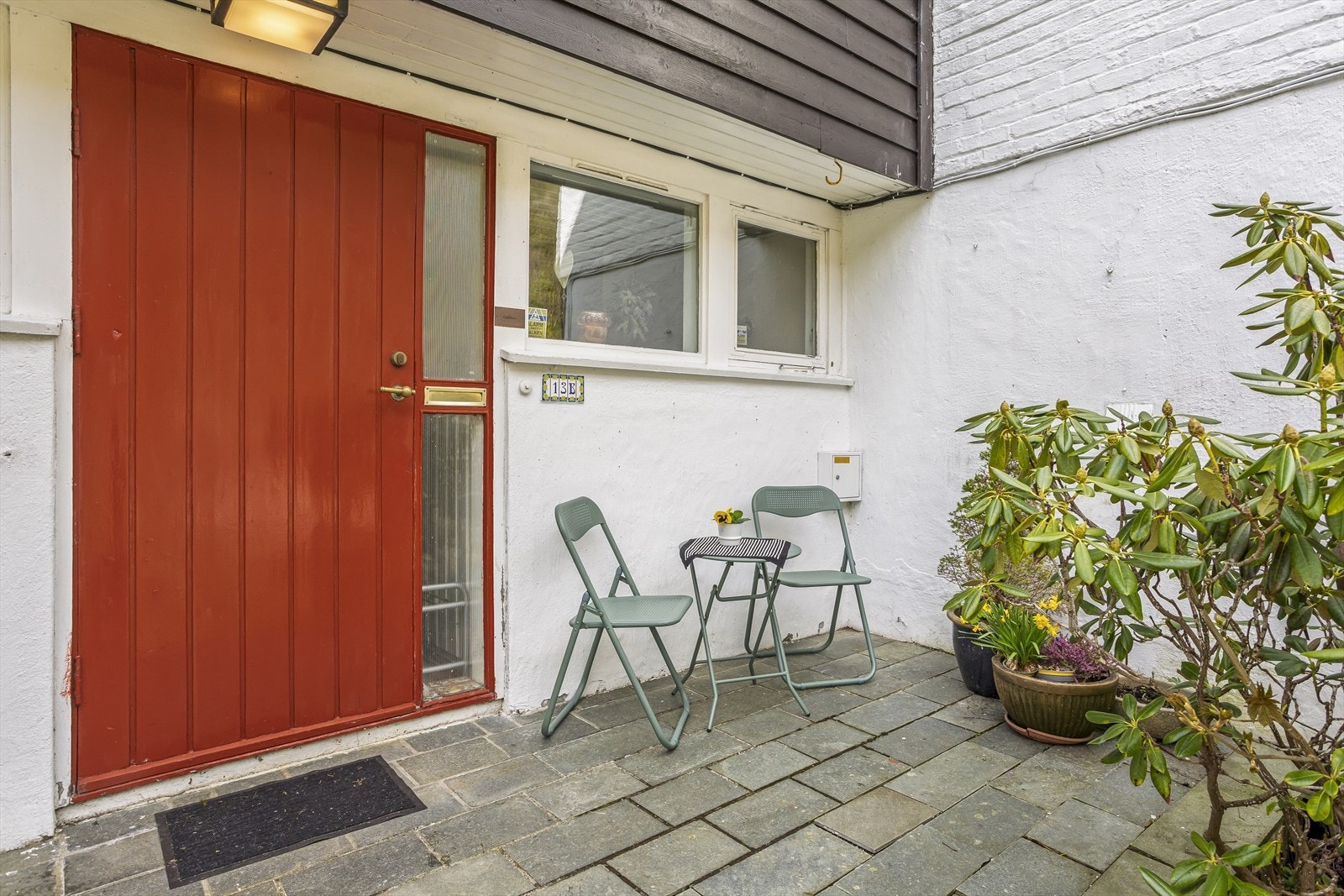 Pent opparbeidet inngangsparti med steinheller og sittekrok. Galleribilde