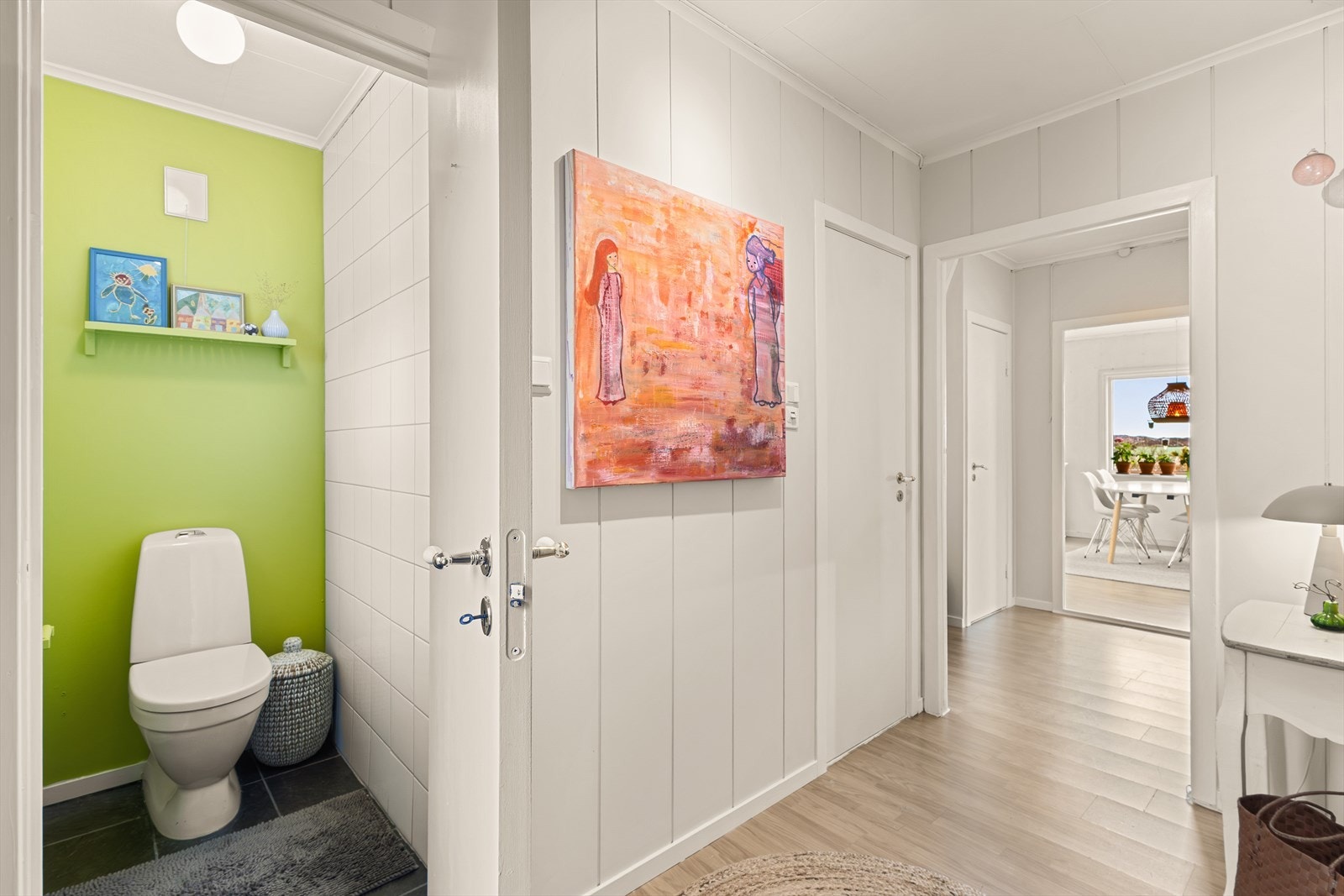 Fra gang er det dør til toalettrom som har keramiske fliser på gulv, og keramiske fliser og malt platekledning på vegger. Galleribilde