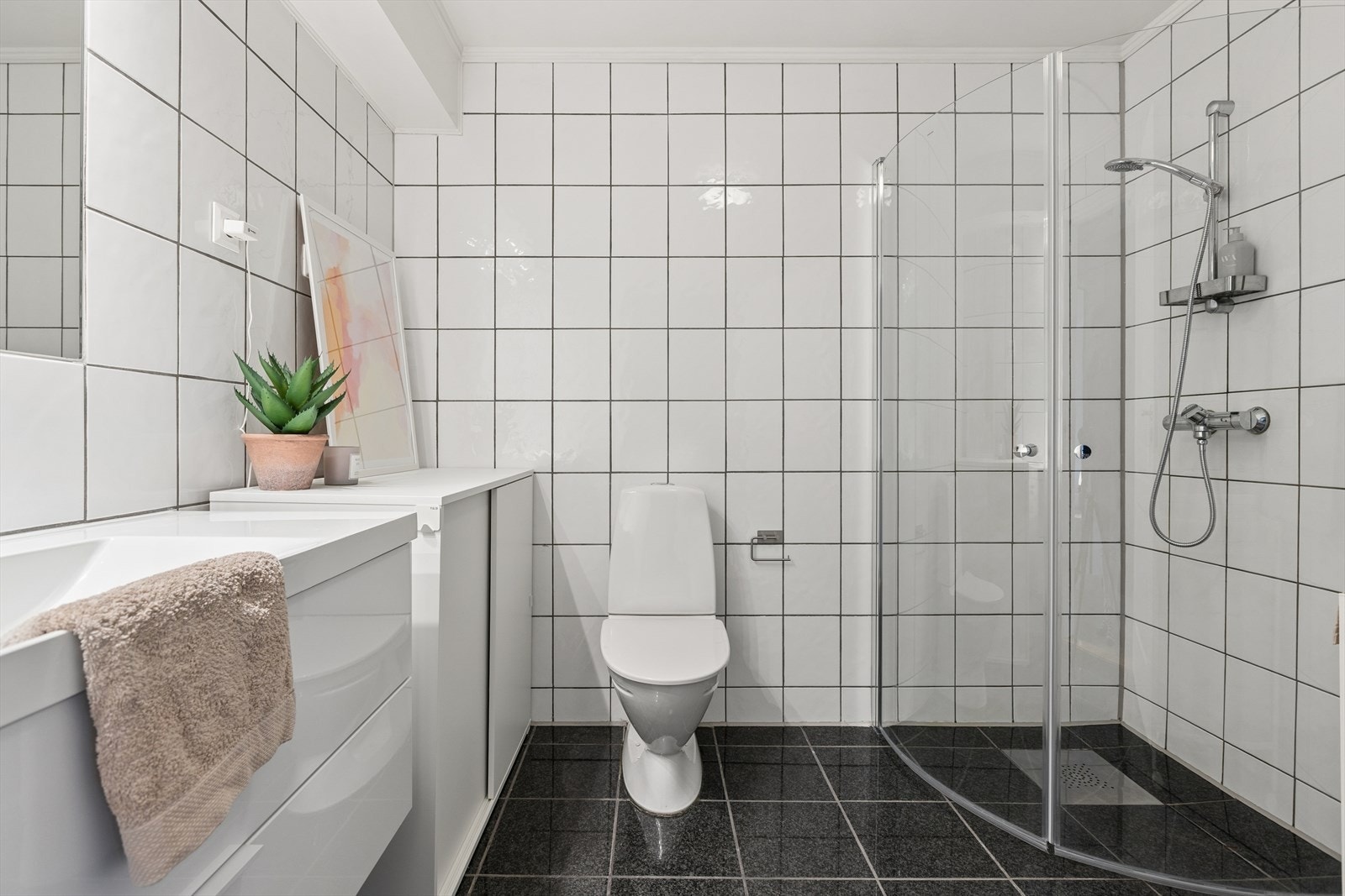 Badet har flislagt gulv med elektriske varmekabler og opplegg for vaskemaskin. Galleribilde