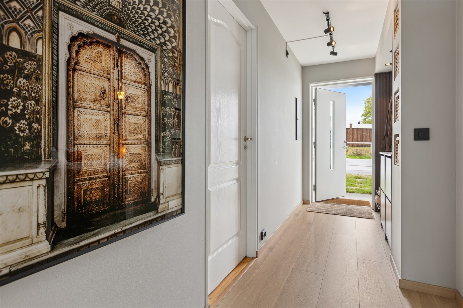 Velkommen inn i den lyse entréen med plass til å henge fra seg yttertøy. Ny ytterdør ble installert i 2025. Galleribilde