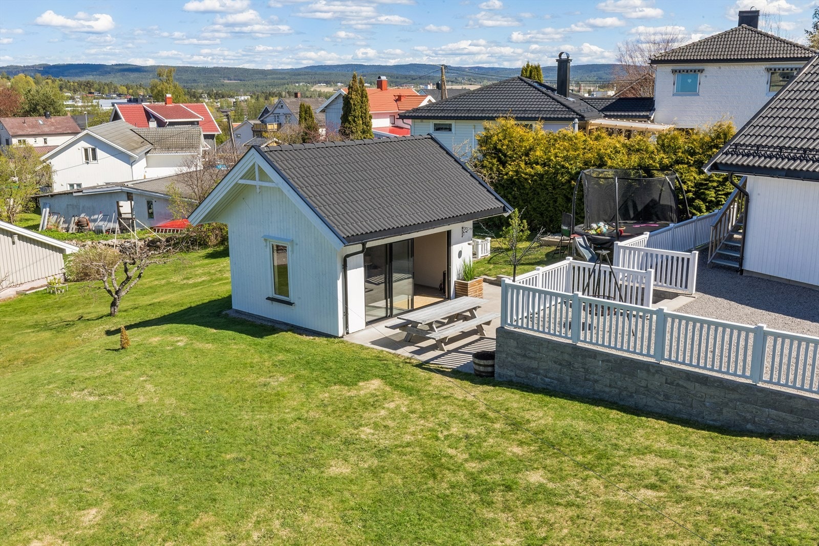 Utestuen har et stort skyvedørsfelt i glass ut mot en støpt platting, som binder inne- og uteområdet sammen. Galleribilde