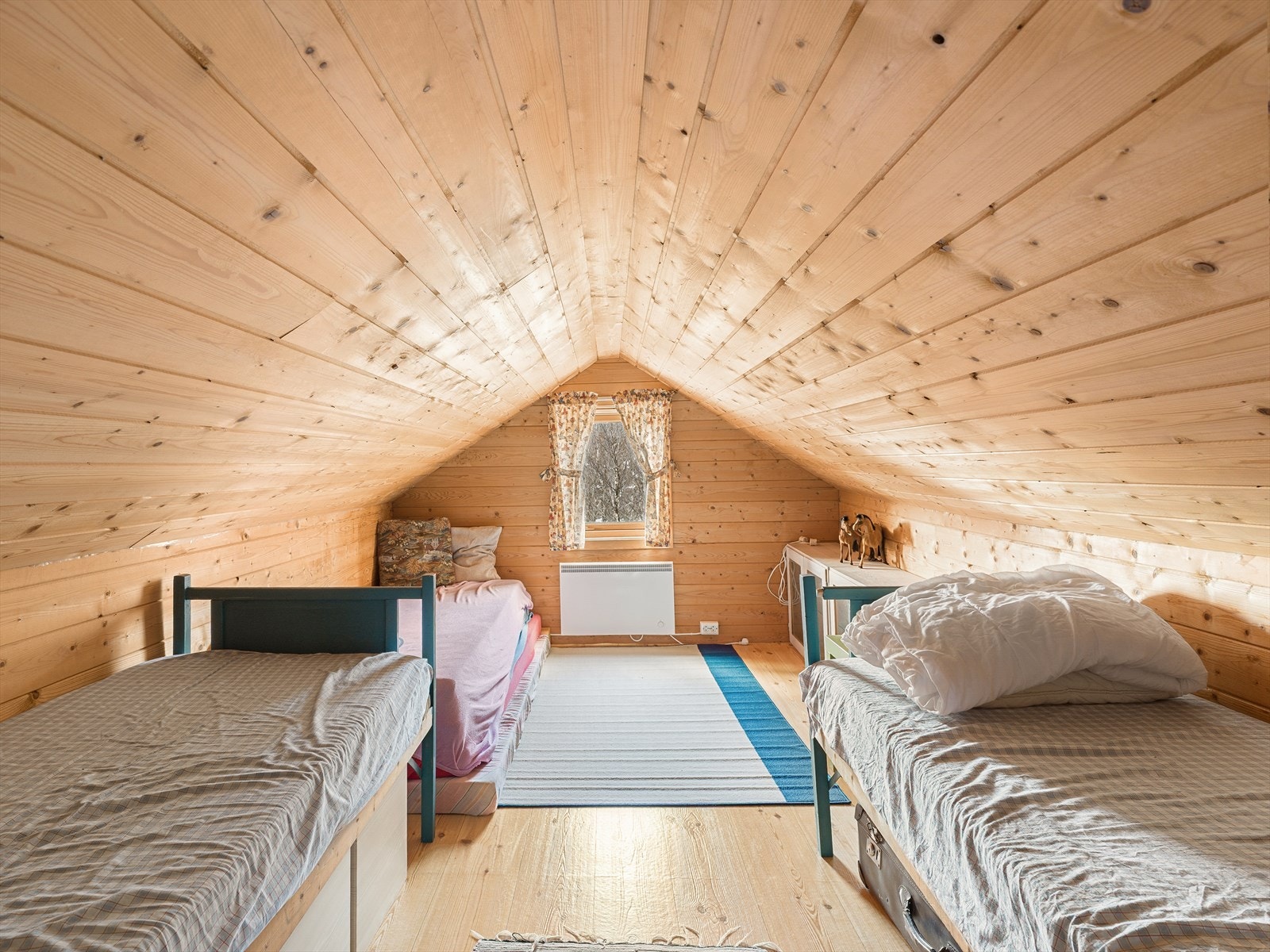 Hemsen er kledd med trepanel på gulv, vegger og i tak, som gir en helhetlig stil. Galleribilde
