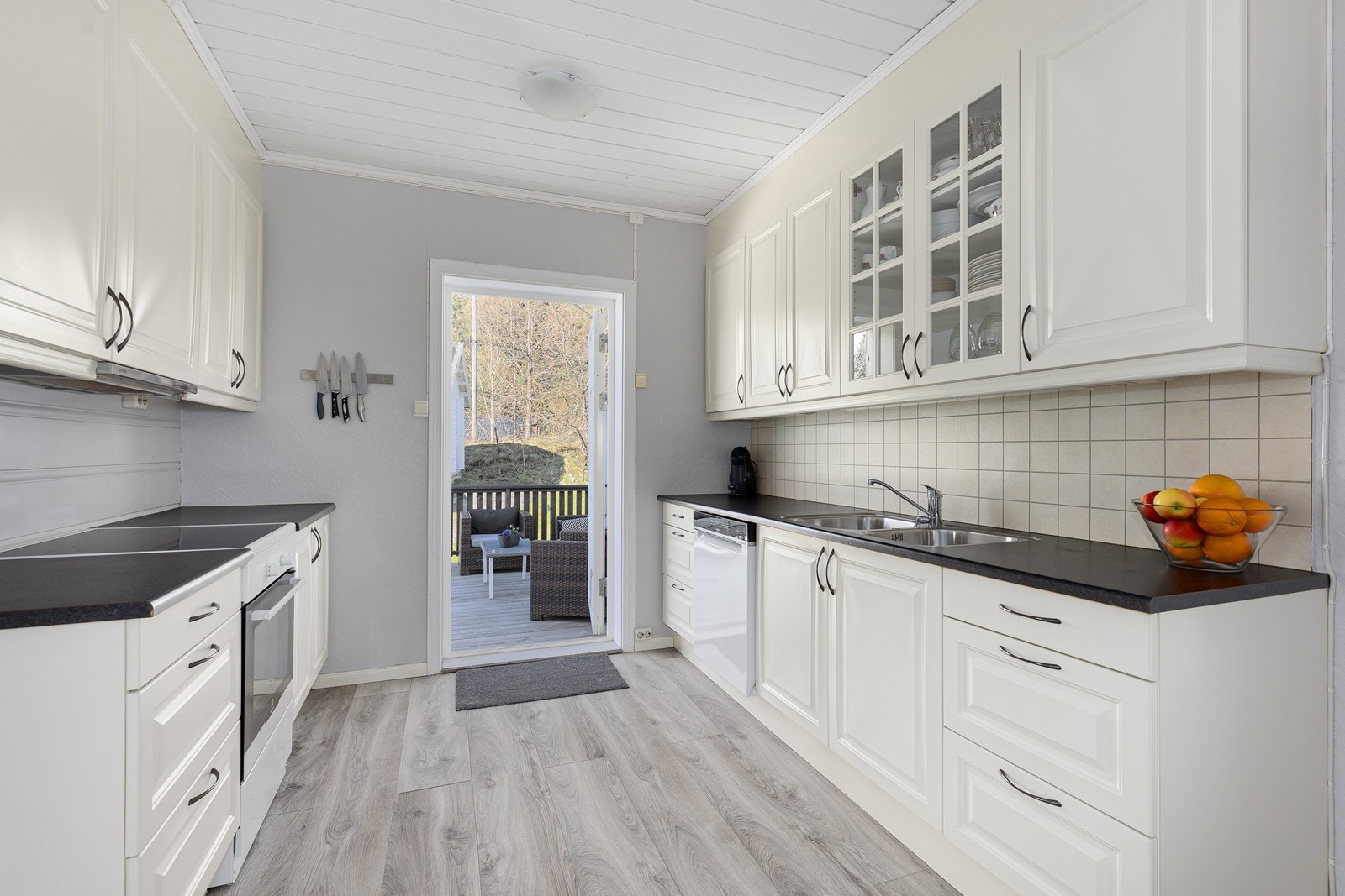 Kjøkkenet har en tidløs innredning i lyse farger og god plass til oppbevaring. Fra kjøkkenet er det også direkte utgang til en solrik terrasse. Galleribilde