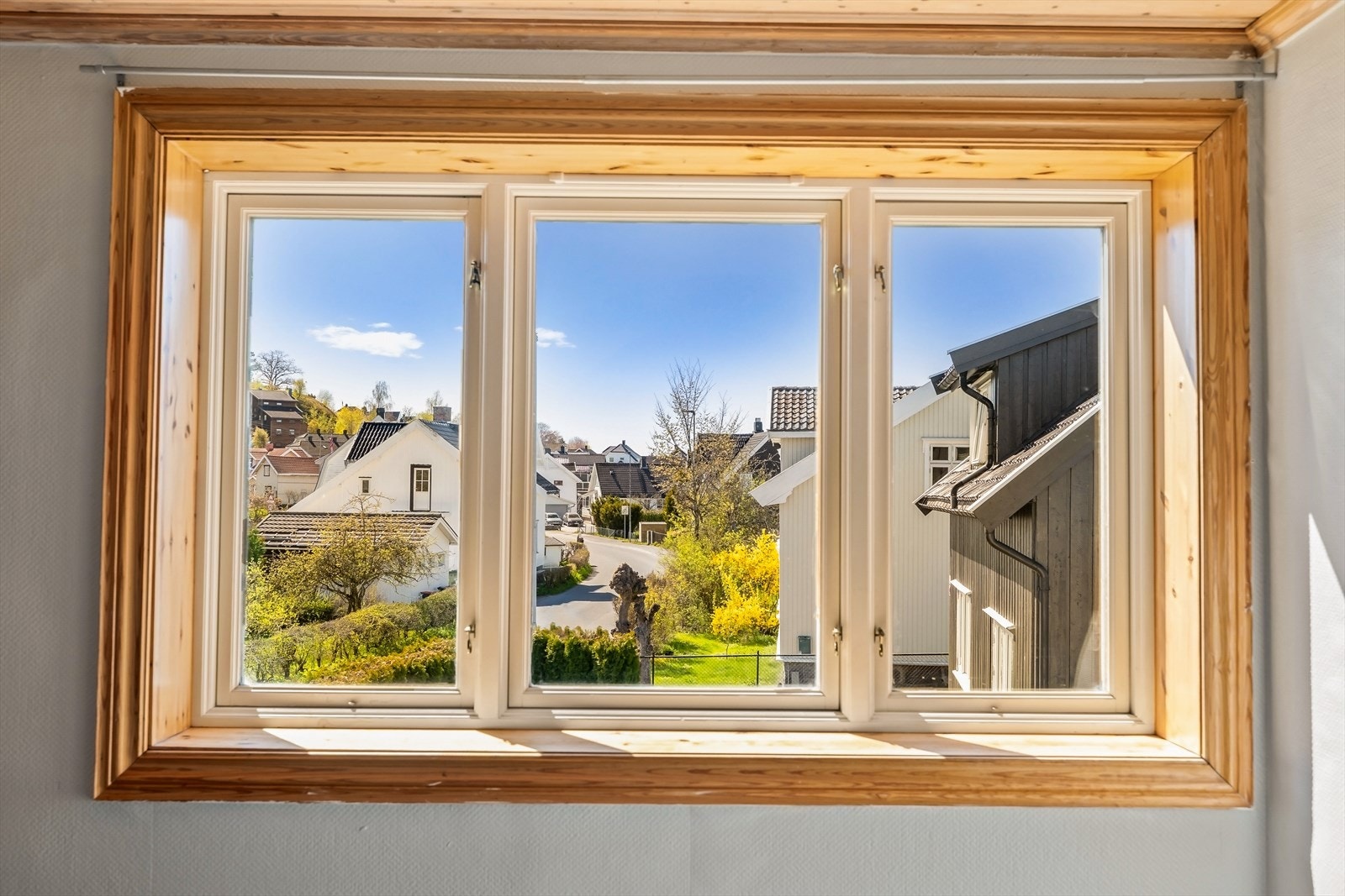 De malte trevinduene med 2-lags glass rammer inn utsikten mot nabolaget. Galleribilde