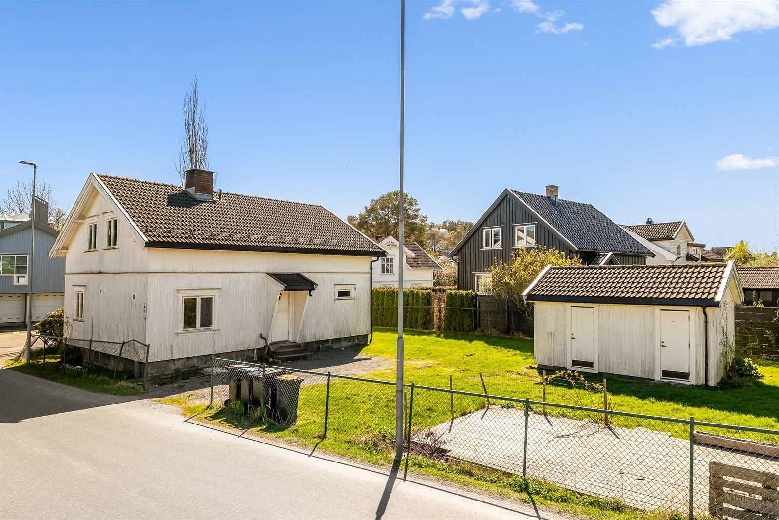 Eiendommen har en romslig hage med plen og en frittstående bod for ekstra lagring. Galleribilde