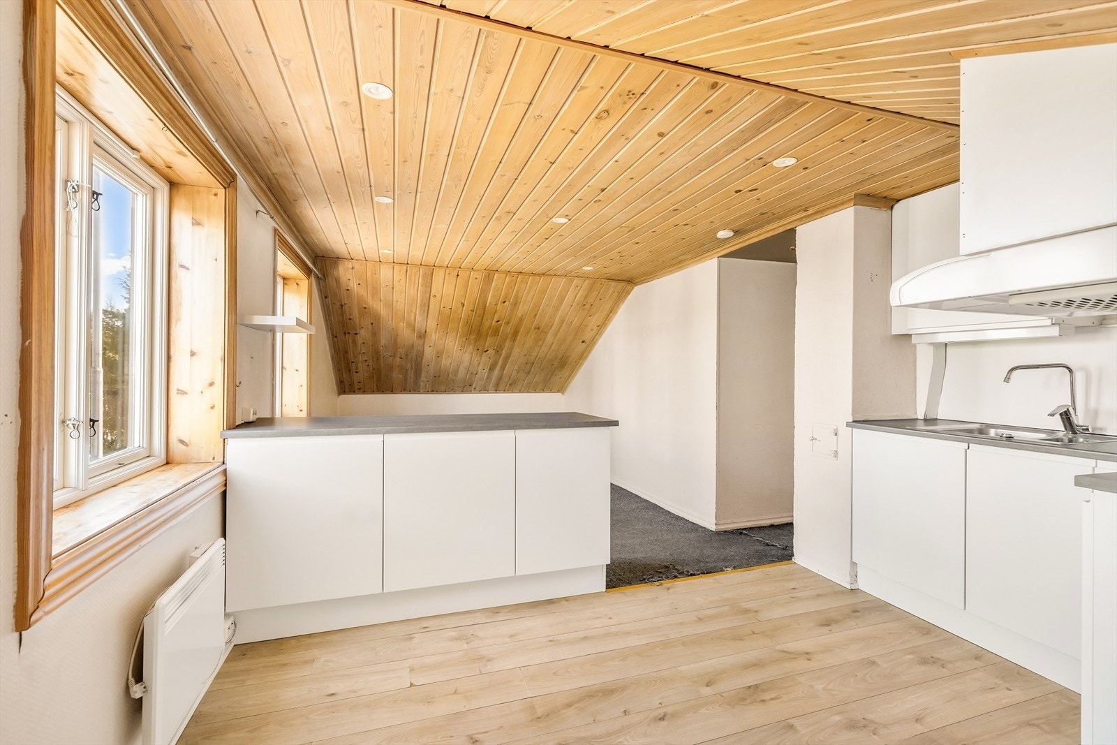 Kjøkkeninnredningen har glatte fronter og laminat benkeplate. Panel i himling gir en lun atmosfære. Galleribilde