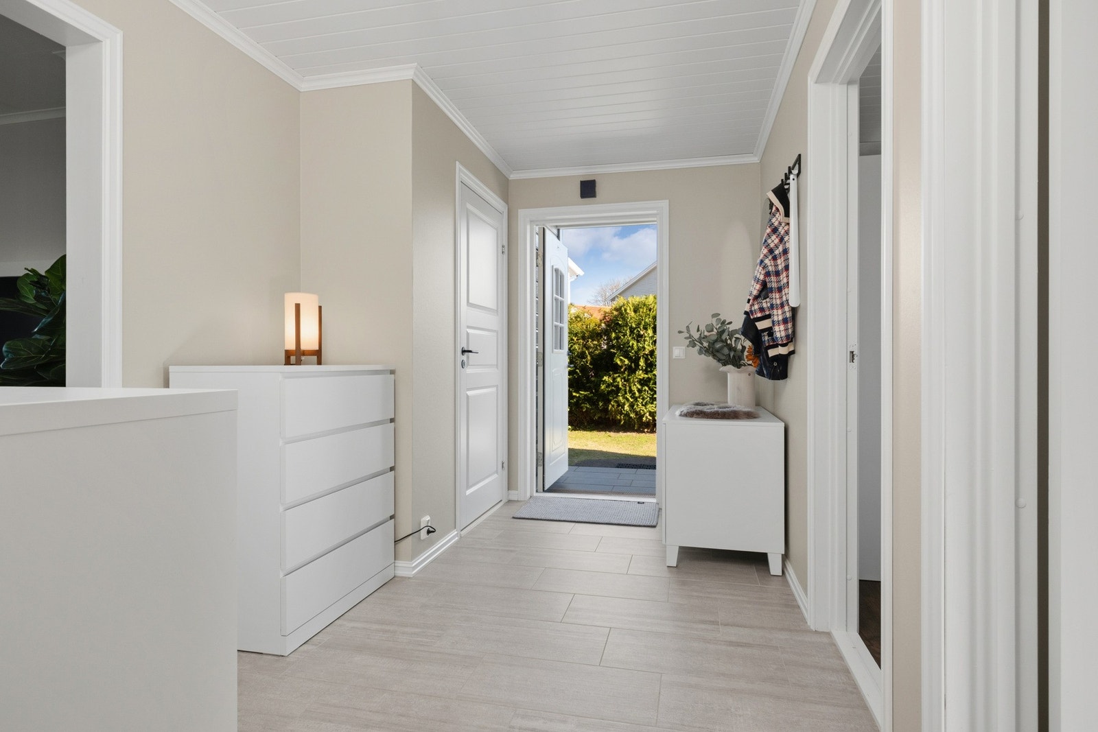 Romslig hall med god flyt videre inn til boligens oppholdsrom. Galleribilde