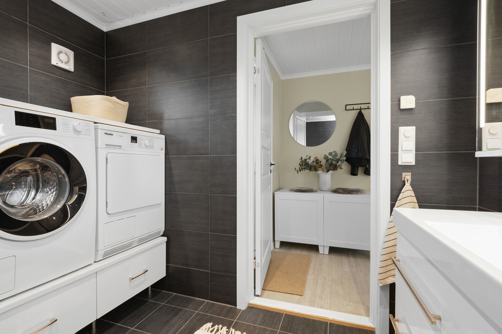 Badet har dusjnisje, opplegg for vaskemaskin og elektrisk styrt ventilasjon. Galleribilde
