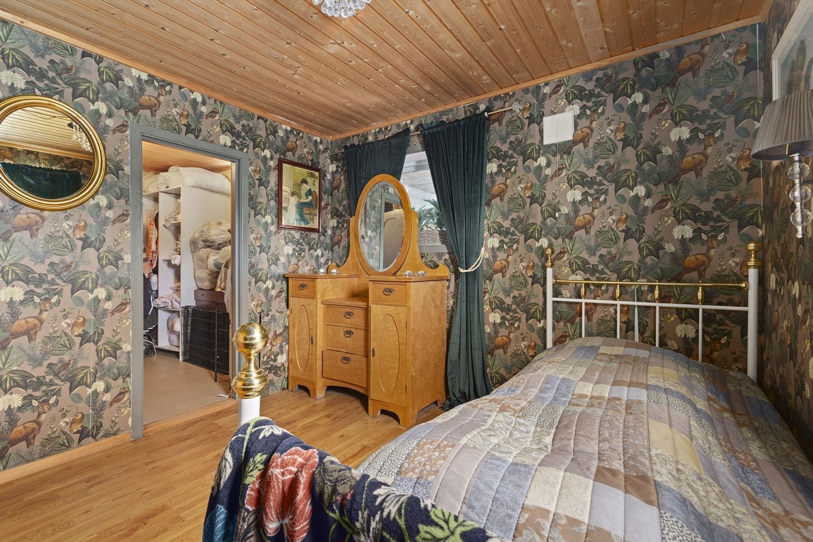Stort soverom med plass til seng og oppbevaringsmøbel. På veggene er det tapet og taket har panel Galleribilde