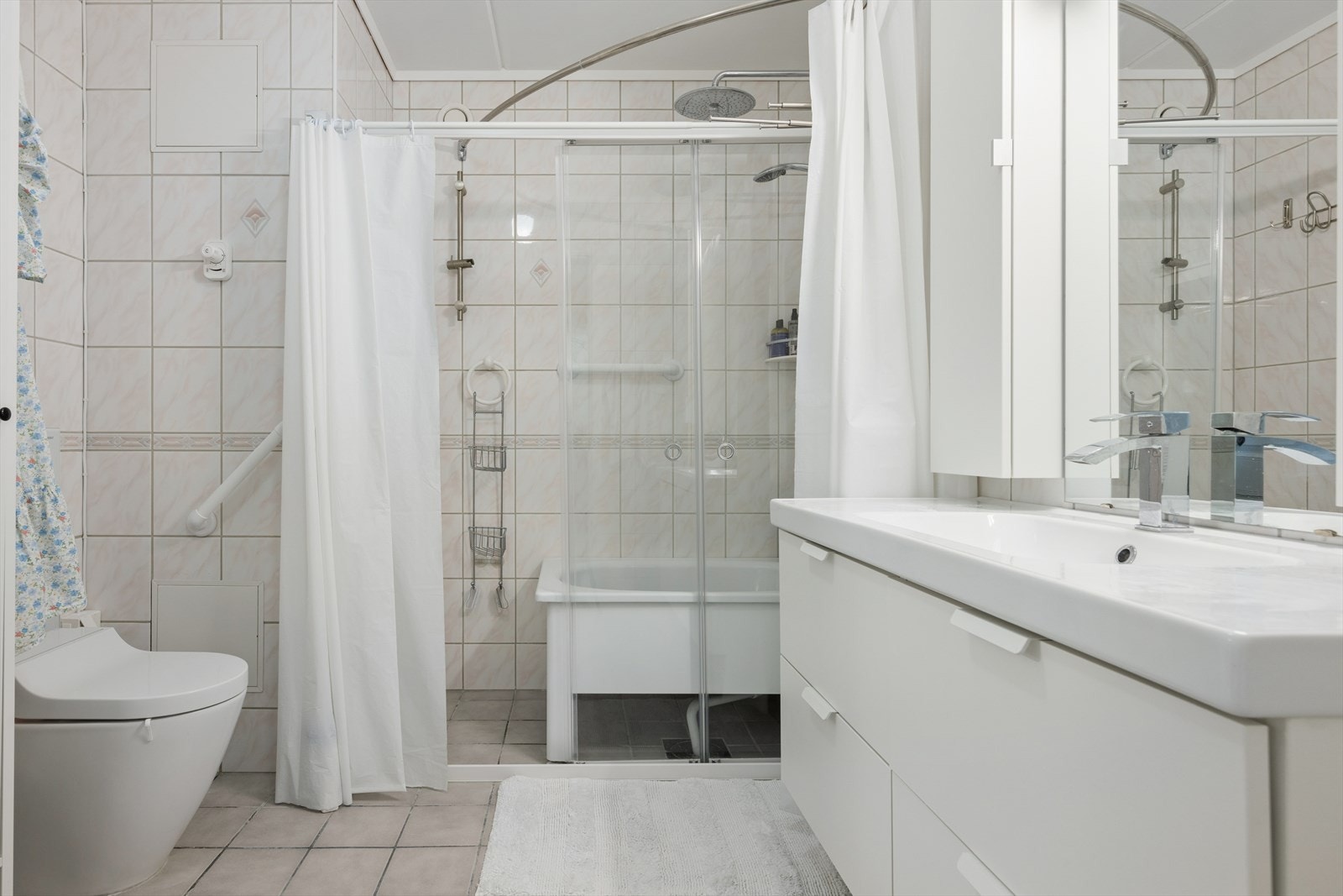 Badet er flislagt og ble oppgradert med nytt badekar og vegghengt toalett i 2023. Galleribilde