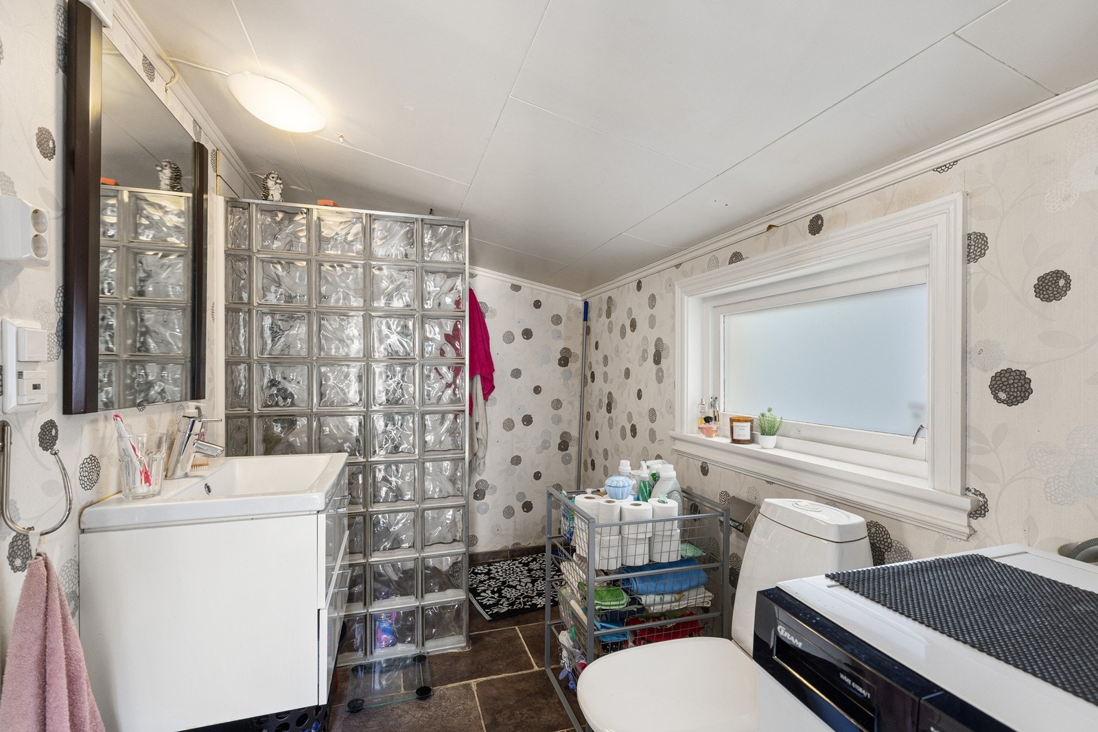 Praktisk bad/vaskerom med funksjonell planløsning, dusjløsning og opplegg for vaskemaskin. Galleribilde