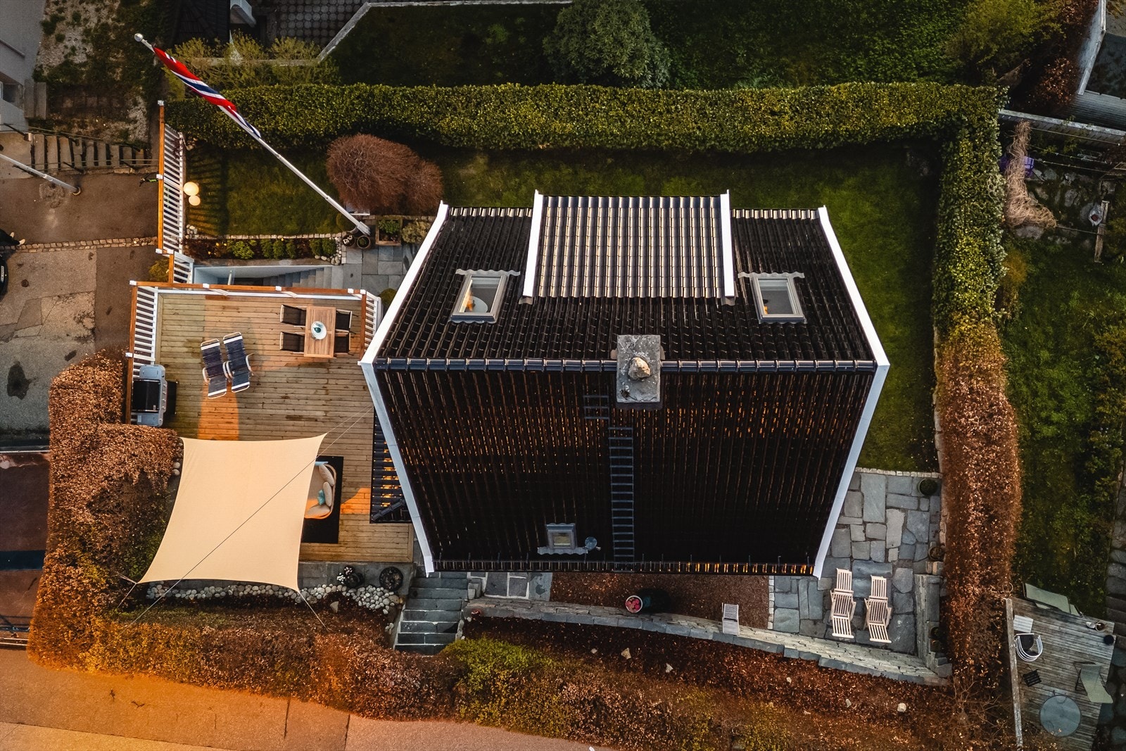Oversikt som viser eiendommens tak, uteplasser og hage. Galleribilde