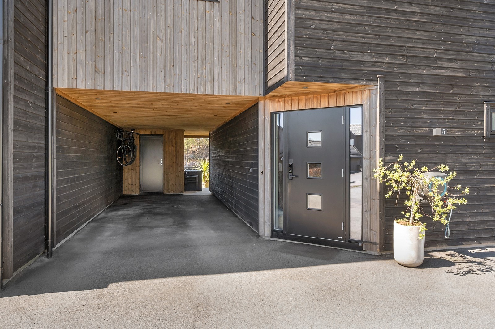 Det er gode parkeringsmuligheter på tomten med egen carport med utvendig bod i enden av den. Spotter i carporten. Gjennomgang til platting og hage på andre siden. Galleribilde