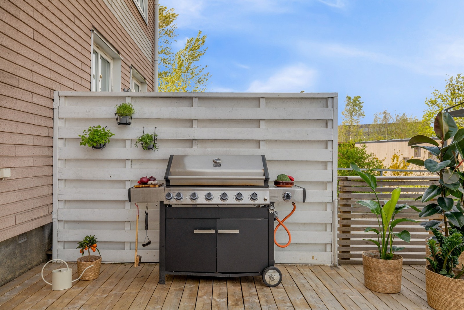 Terrassen har terrassebord på gulv, rekkverk med liggende trespiler og levegger mot naboene. Galleribilde