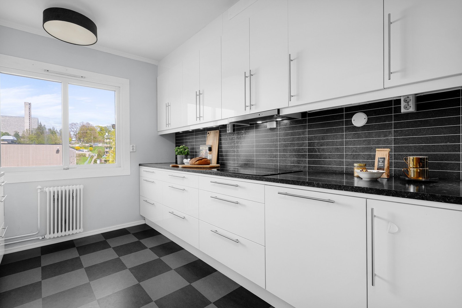 Leiligheten har et lyst separat kjøkken med laminat på gulv og lysmalte overflater. Galleribilde